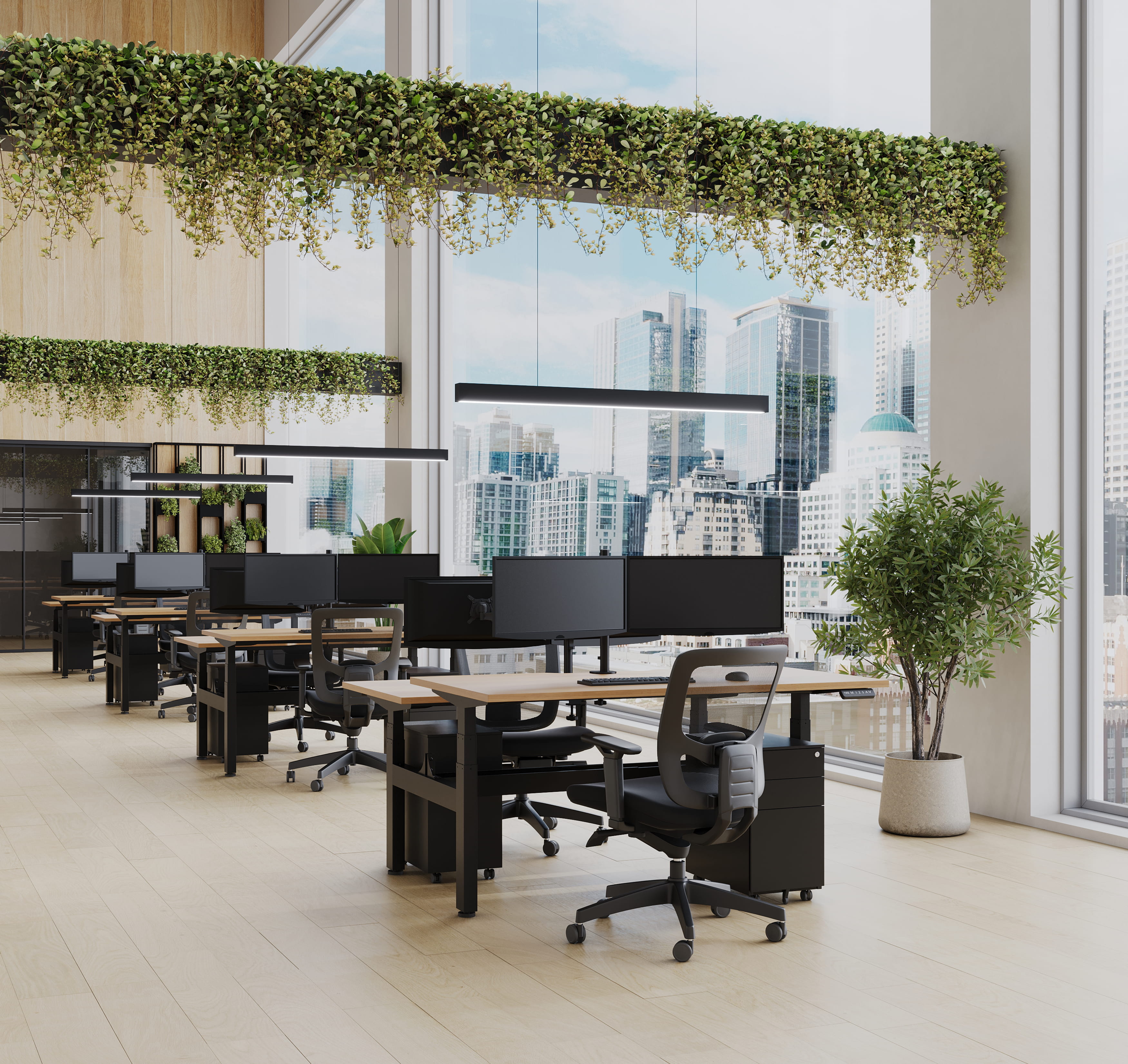 Bright open office with desks, ergonomic chairs, and indoor plants by large windows