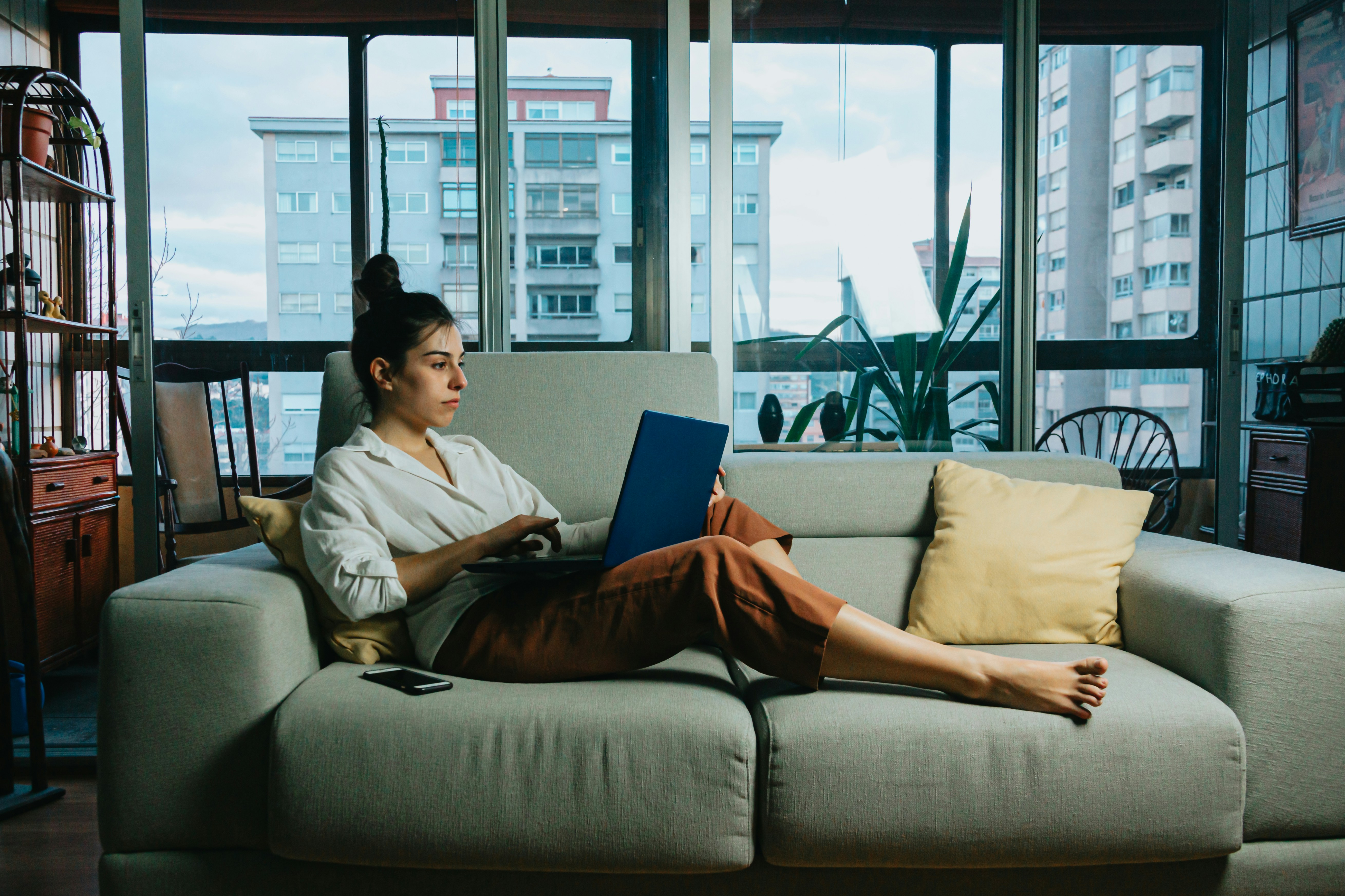 woman on couch working - How Many Sources Should A Research Paper Have