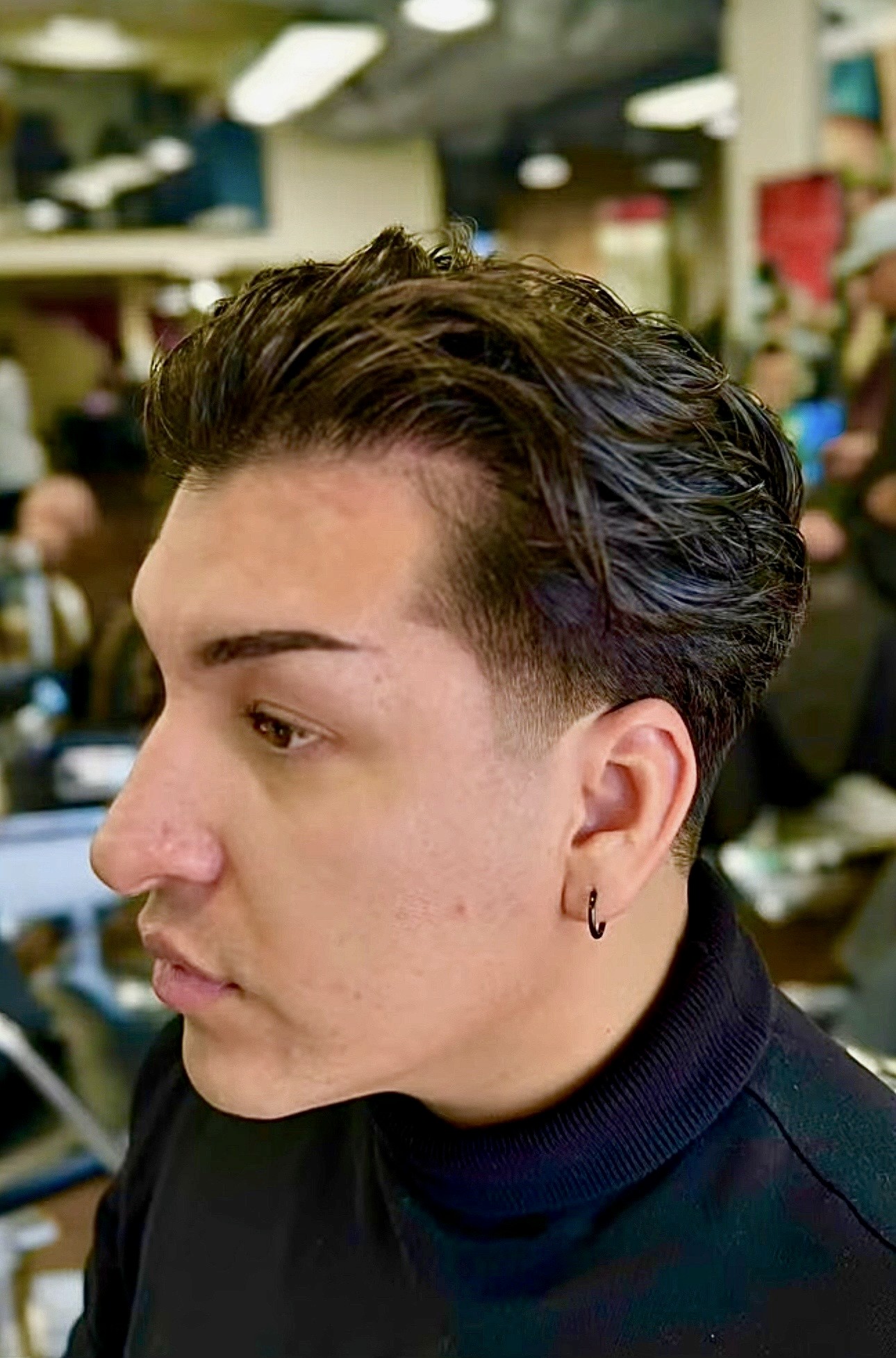 Textured brunet cut with a soft fade, styled for a modern and sophisticated men’s look.