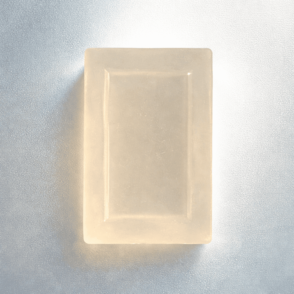 Good Day translucent unwrapped soap on frosted glass with backlighting, top view highlighting transparency and clean minimal studio aesthetic