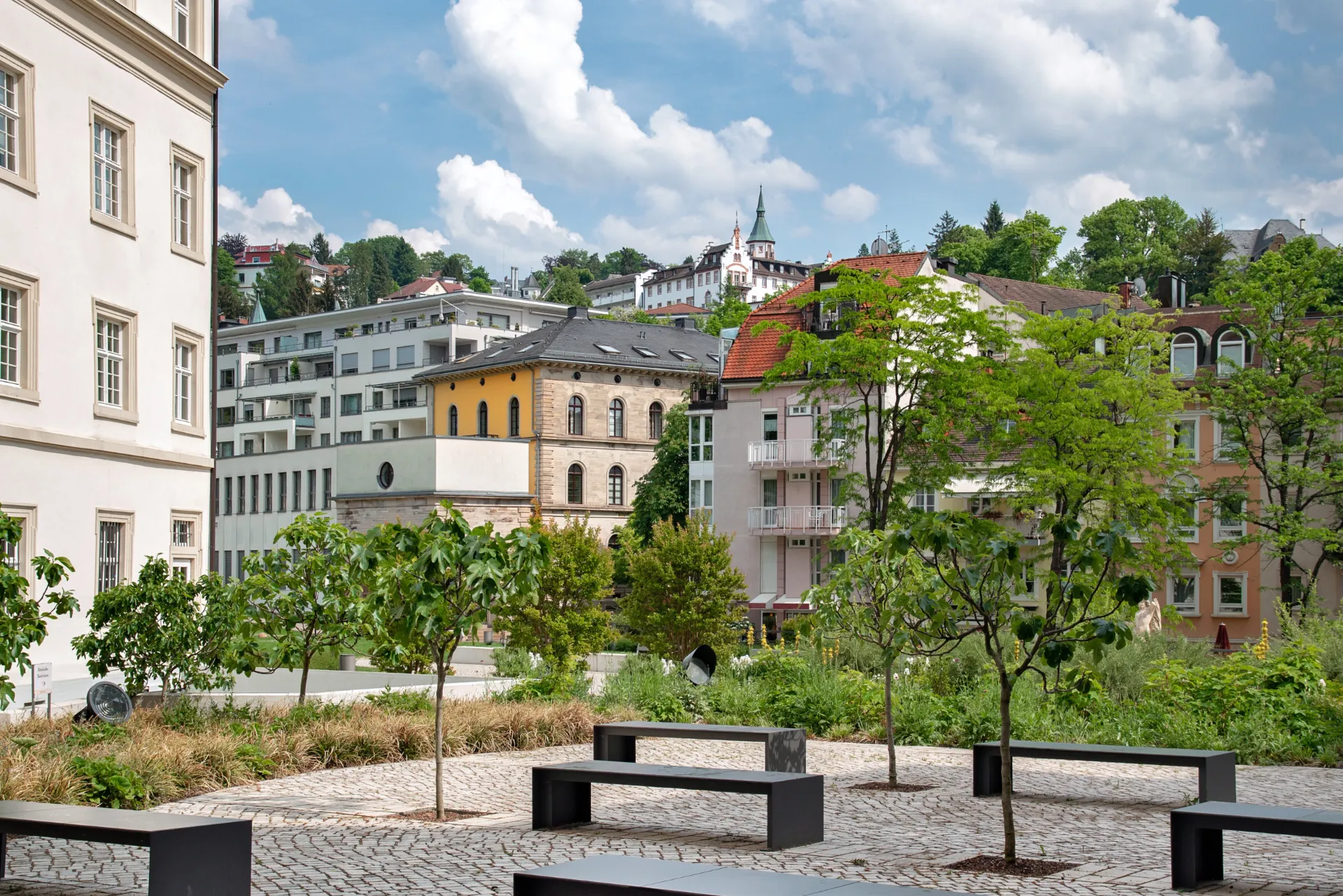 Ein Marktplatz, mit mehreren Bänken verteilt in Baden-Württemberg. Drumherum sind mehre kleine Gebüsche und Bäume.