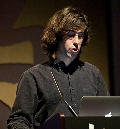 portrait of a student dressed in black giving a speech