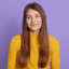 selective focus photo of woman standing in front of bed of yellow petaled flowers