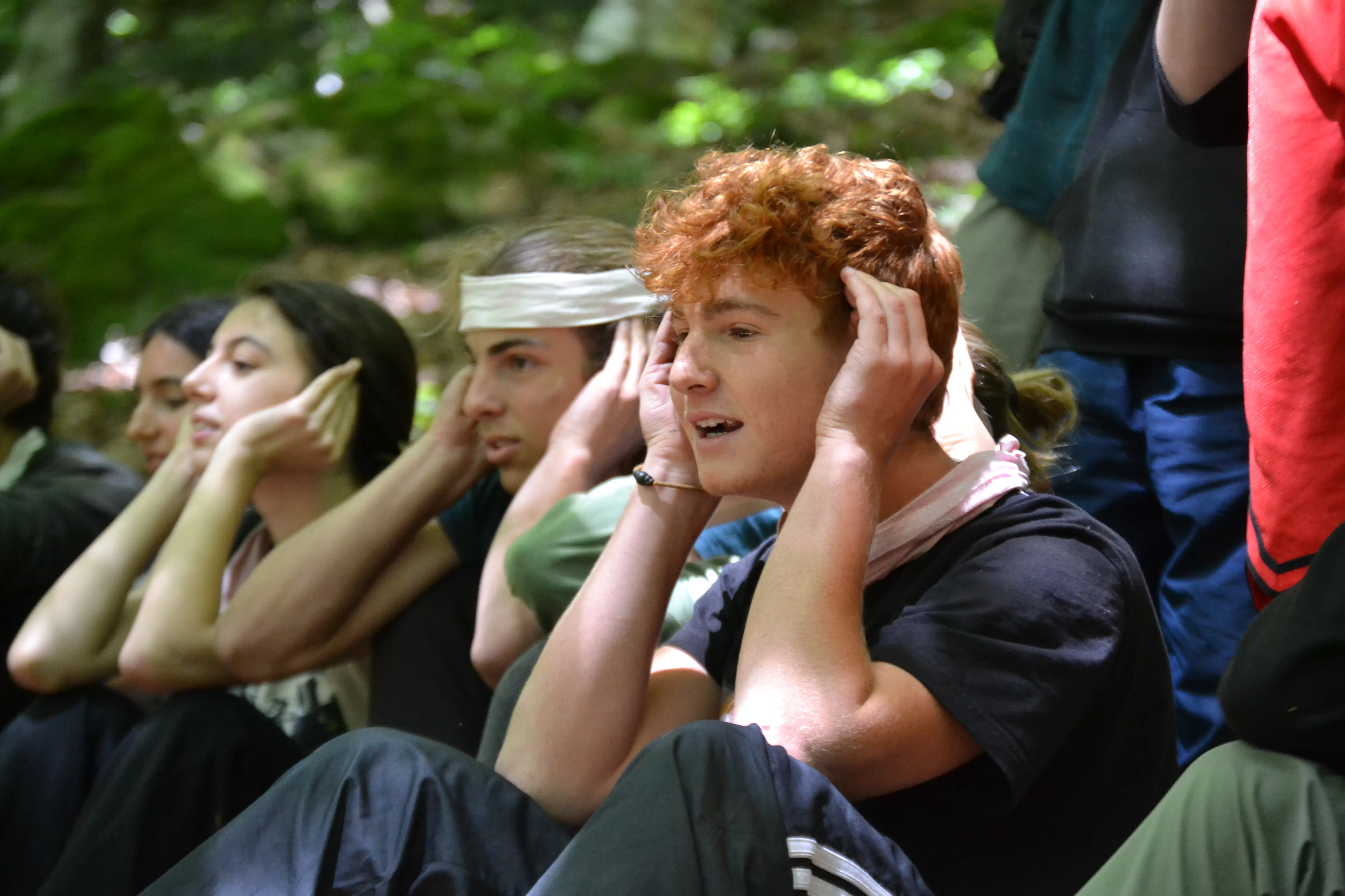 Ragazzi praticano ascolto attivo nella natura durante attività di outdoor education, campi estivi per ragazzi e percorsi di crescita personale