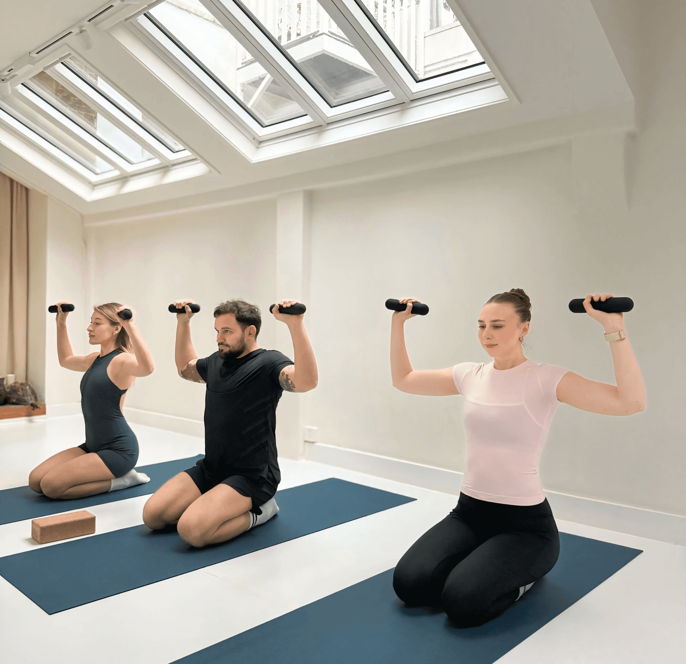 A winding road cuts through rocky terrain, surrounded by patches of green grass and illuminated by sunlight.