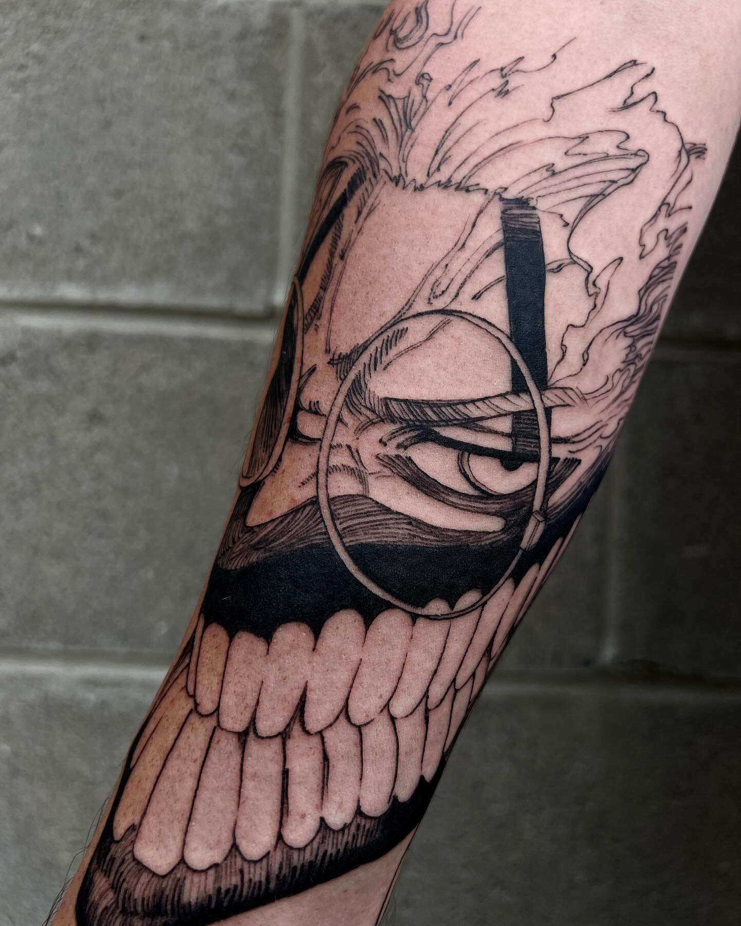 This forearm tattoo captures Okarun in his transformed state with an intense, sinister grin. The exaggerated teeth, wild hair, and sharp, angular details radiate energy and chaos, while the manga-inspired linework emphasizes his raw, otherworldly power. A perfect tribute to Okarun's most feral moments in Dandadan.