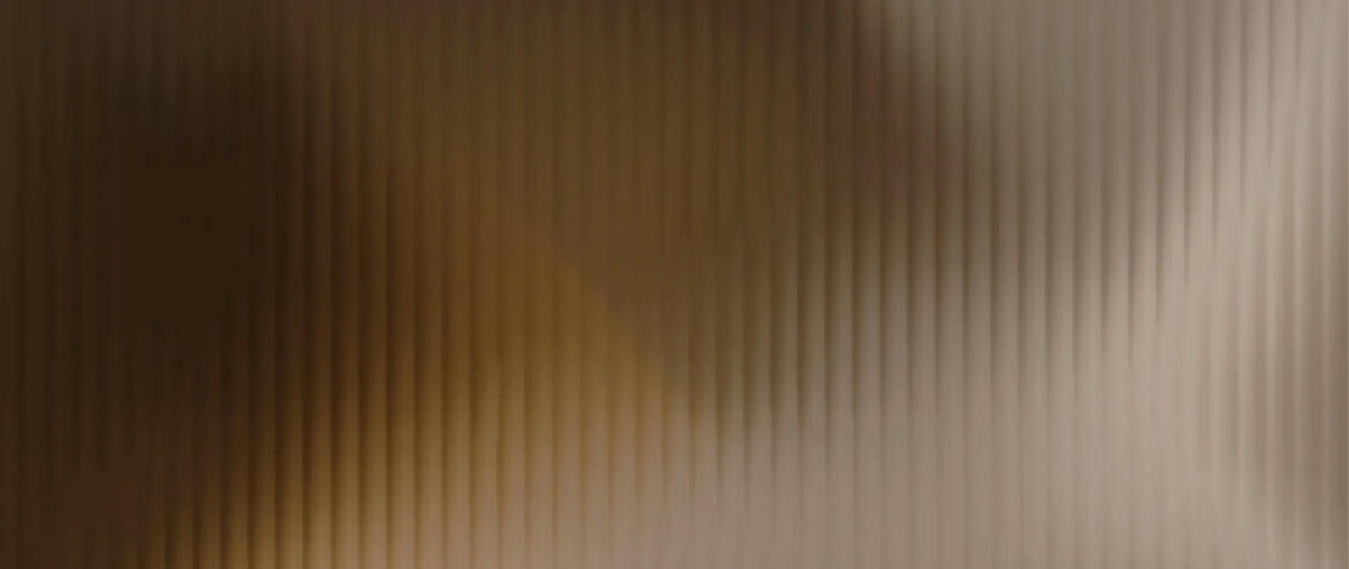 Abstraktní pozadí s texturou v teplých zemitých tónech a hrou světla, navozující pocit stability, důstojnosti a naděje.