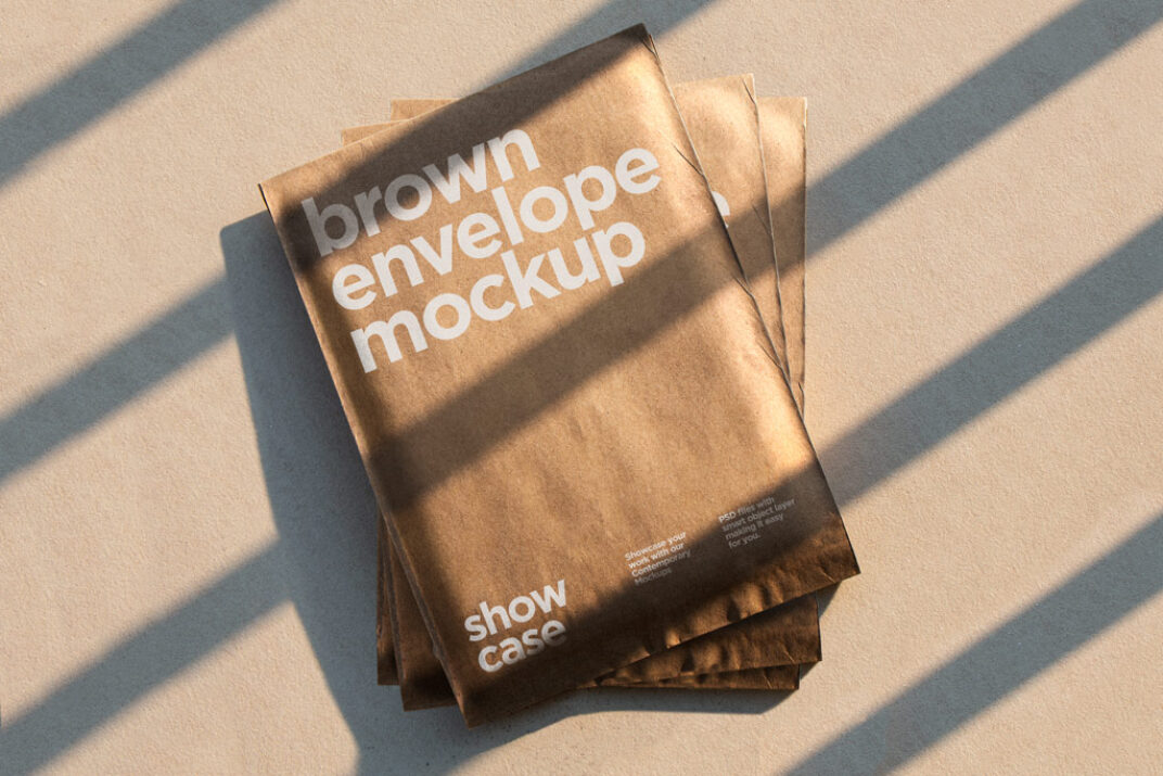 Stack of brown kraft envelopes arranged on a beige surface, illuminated by sunlight casting bold linear shadows. The envelopes feature a minimalist design with a natural aesthetic.