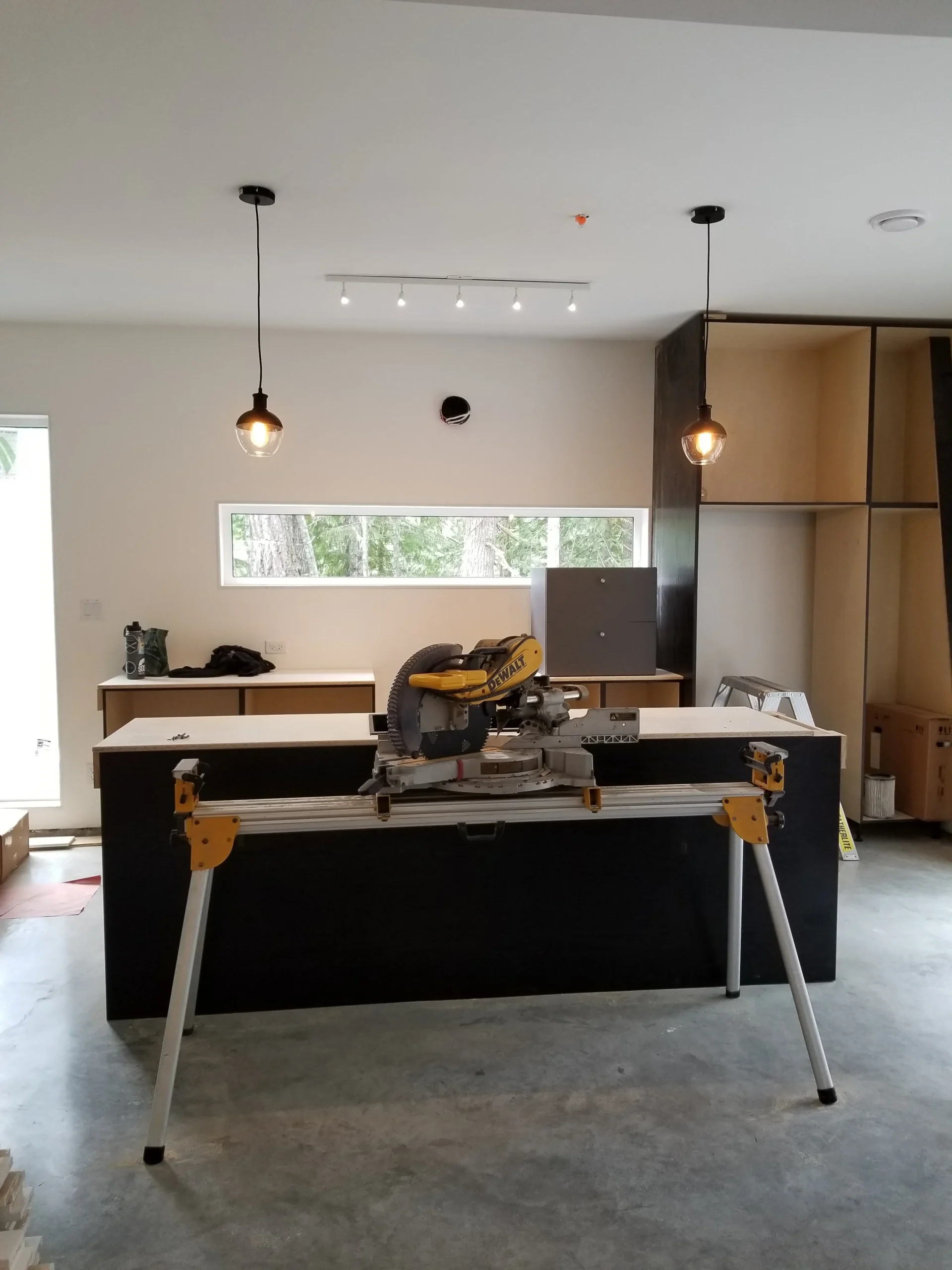 Modern two-story home with large glass windows, warmly lit interiors, and a balcony. Surrounded by trees and a manicured lawn at dusk. Cozy ambiance.