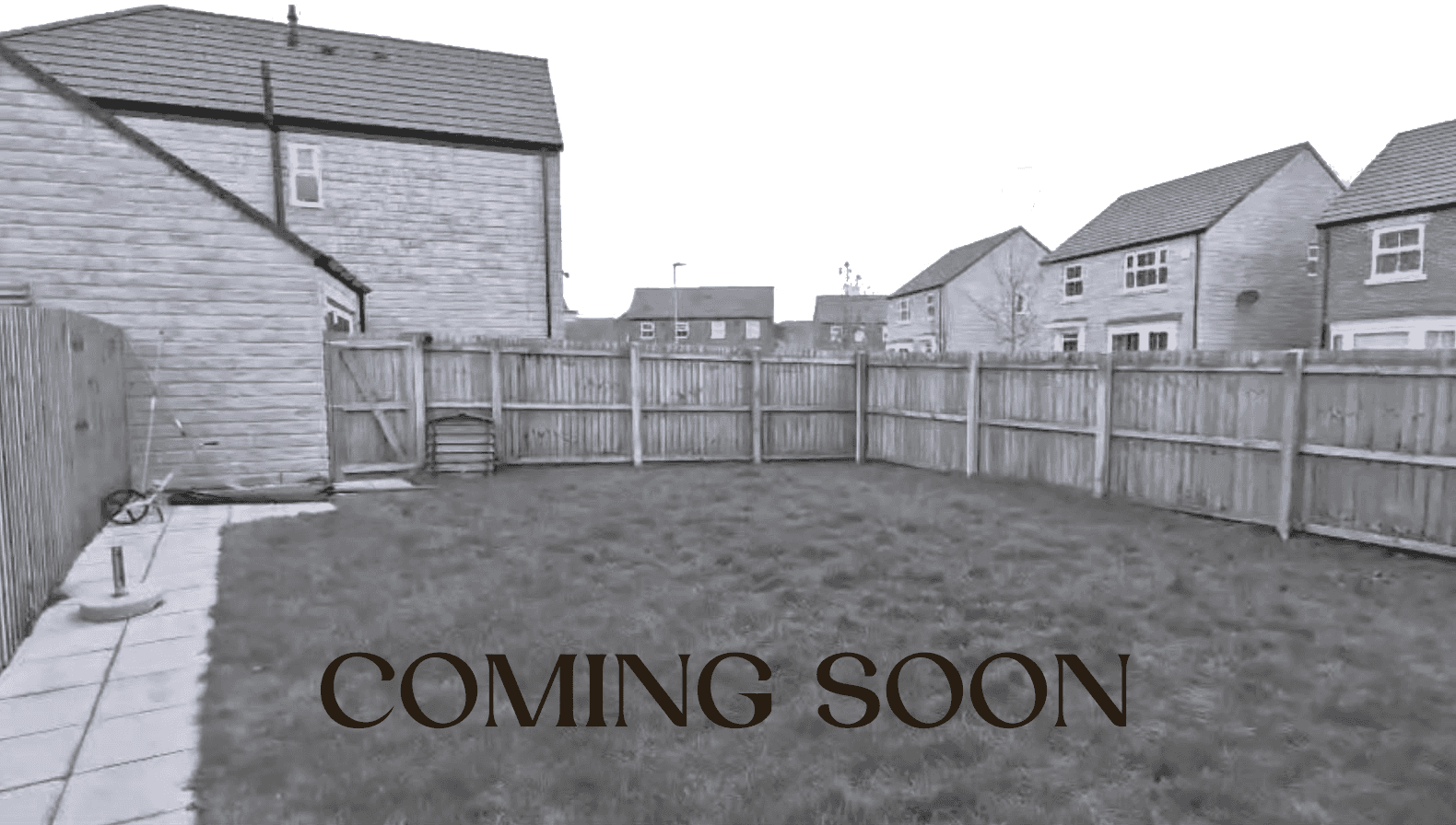 A modern outdoor patio features a sleek, black metal pergola with a built-in grill, surrounded by lush green planting with glimpse views to a cedar clad garden room, offering a stylish and serene garden oasis.