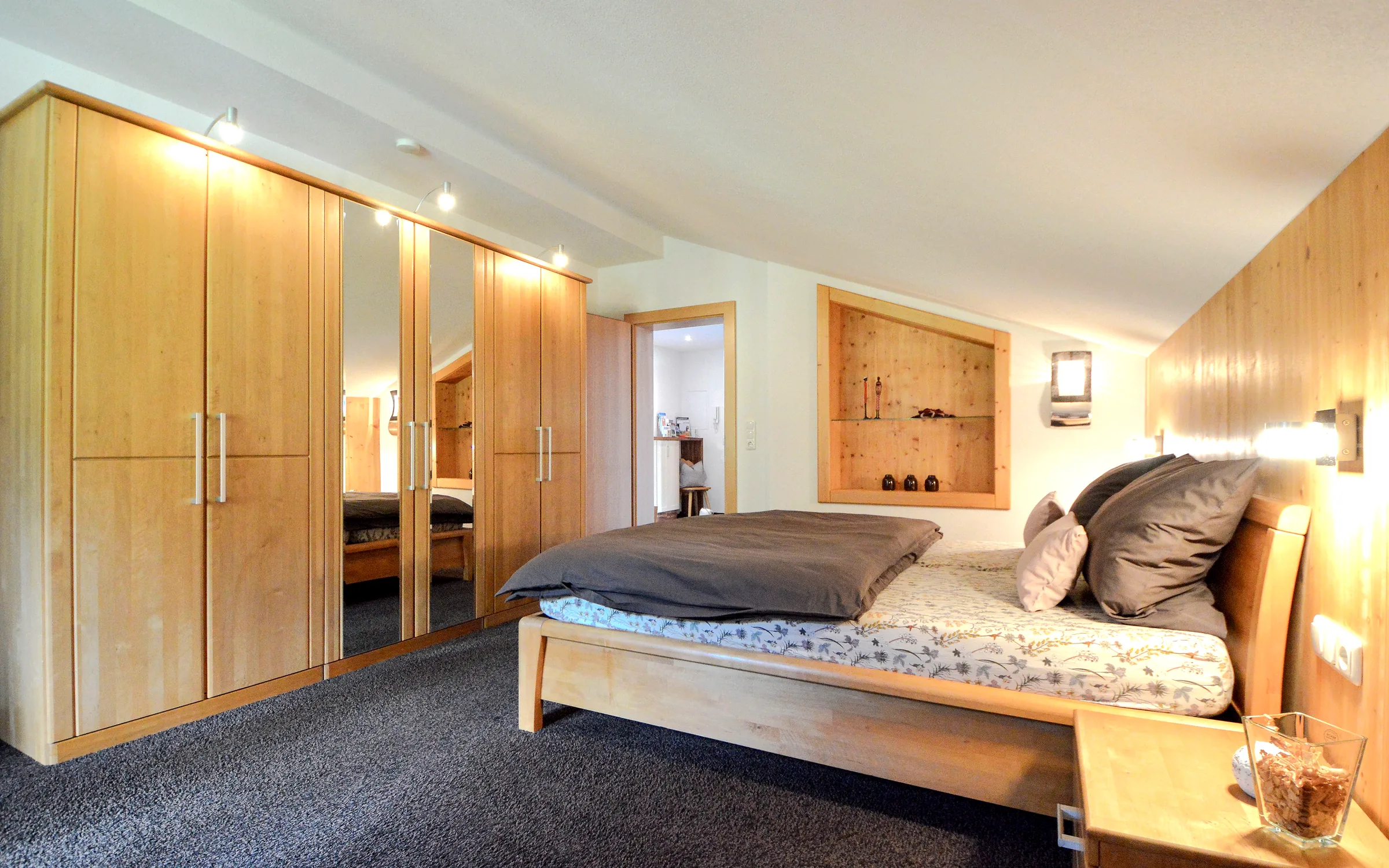 Schlafzimmer mit Doppelbett, großem Kleiderschrank und Holzvertäfelung