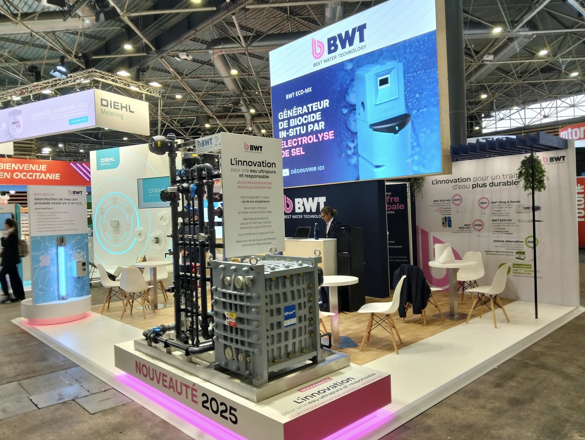 Stand BWT Pollutec 2025 conçu par Expace – exposition du générateur de biocide in-situ ECO-MX et du système d'électrodéionisation nouvelle génération, avec écran LED grand format et podium lumineux rose