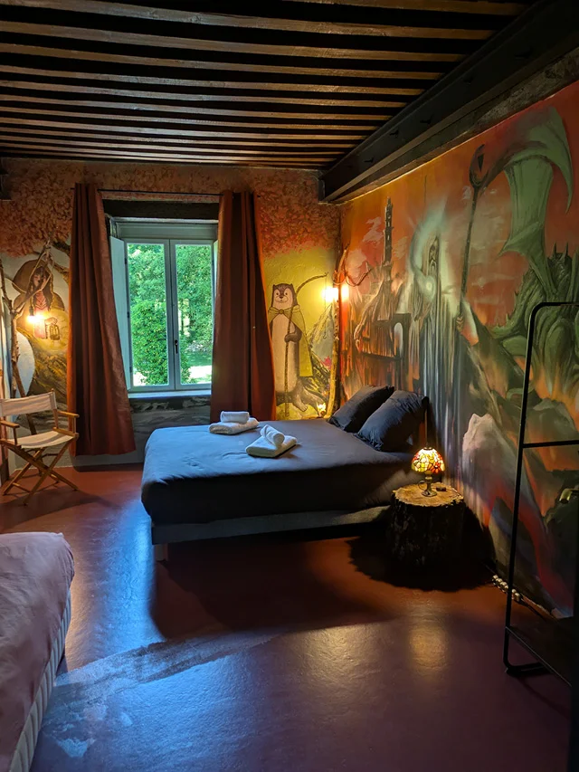 Vue du lit et du décor fantastique de la chambre La Forêt de Tuilwyn au gîte La Tuilerie du Cinéaste