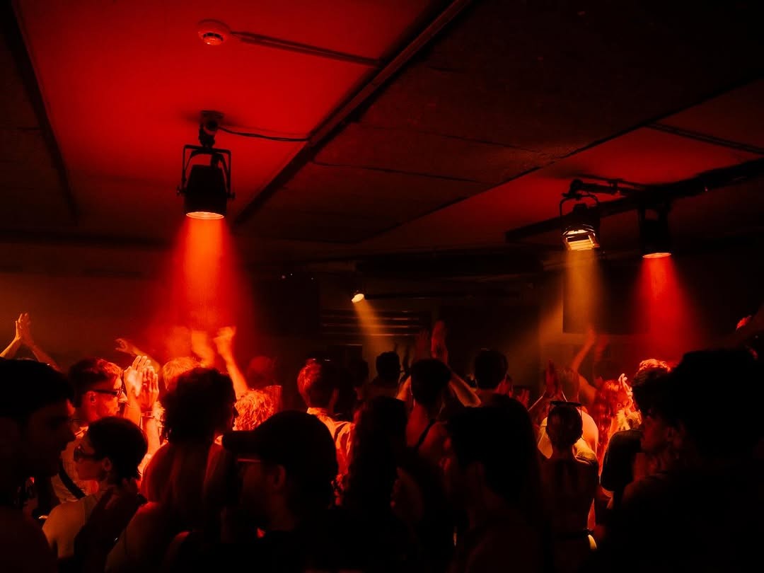 Red neon-lit lounge seating and bar interior at Nocturne Club