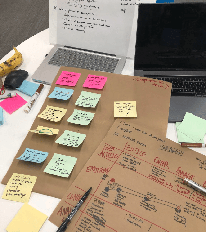 Modern home office setup with a monitor, ergonomic chair, keyboard, and indoor plants near a window with blinds.