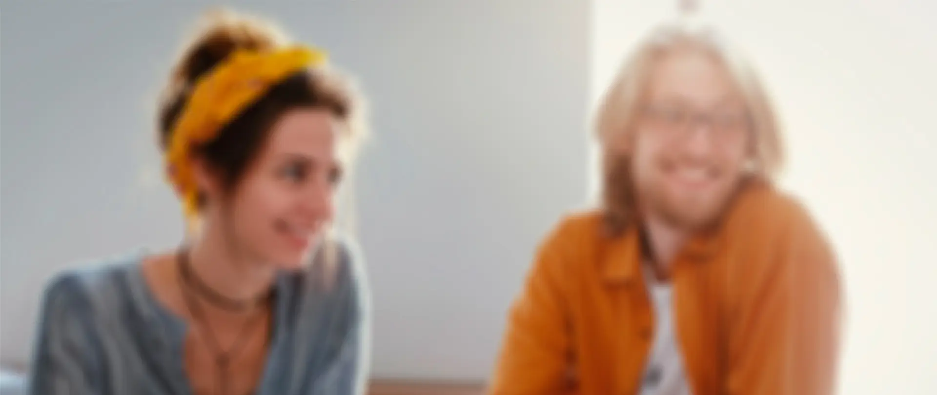 Záběr na usměvavé tváře lidí v přátelském rozhovoru, symbolizující lidský přístup, otevřenost a pozitivní energii týmu.