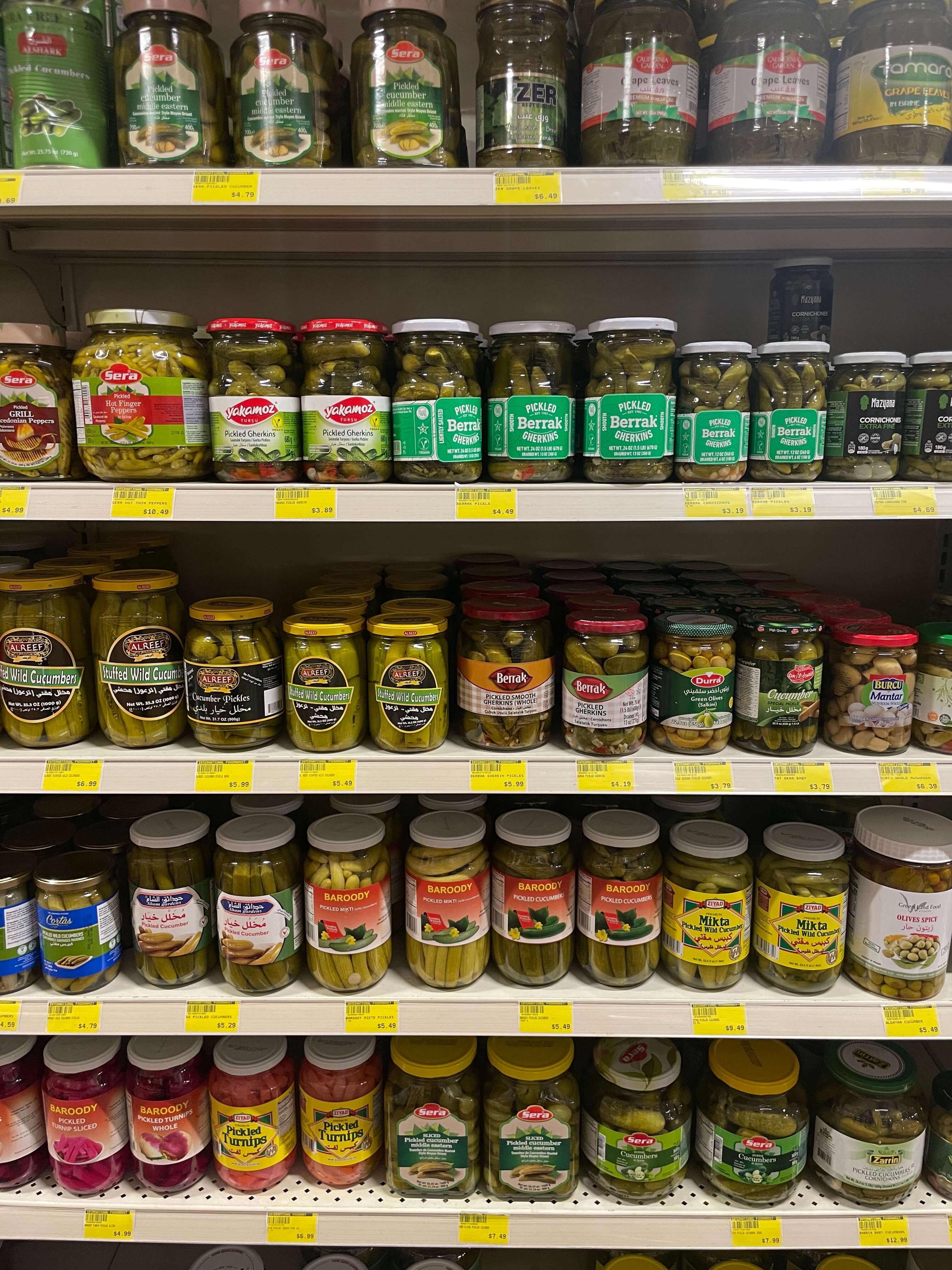 Assorted pickles and olives in jars available at International Food Market Orlando.