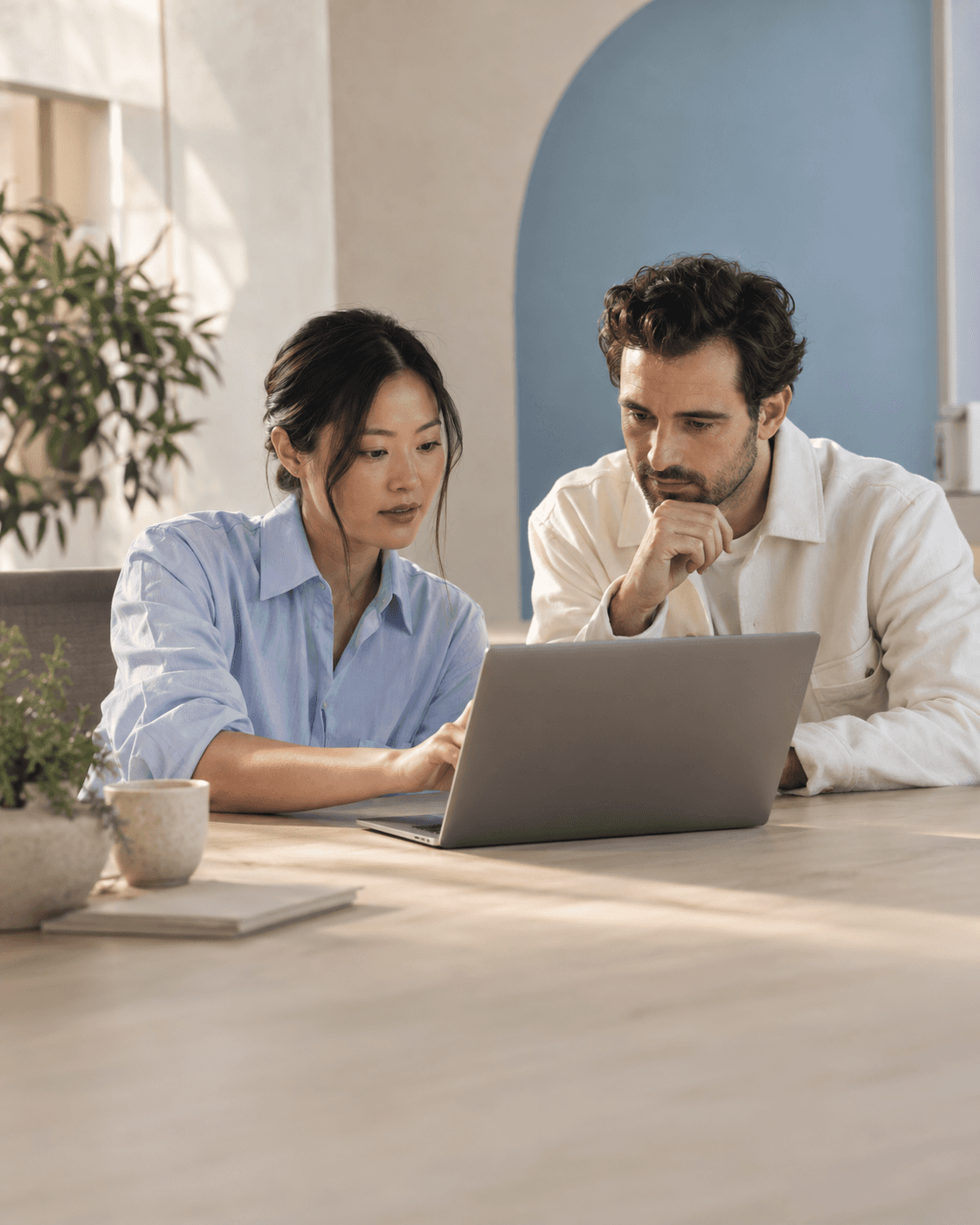 Illustrative image of two colleagues reviewing customer service work in a bright office.
