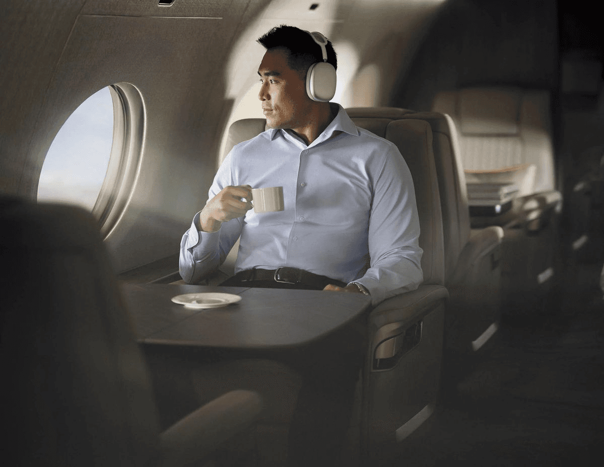 un homme tenant une tasse de café dans l'avion en regardant par le hublot