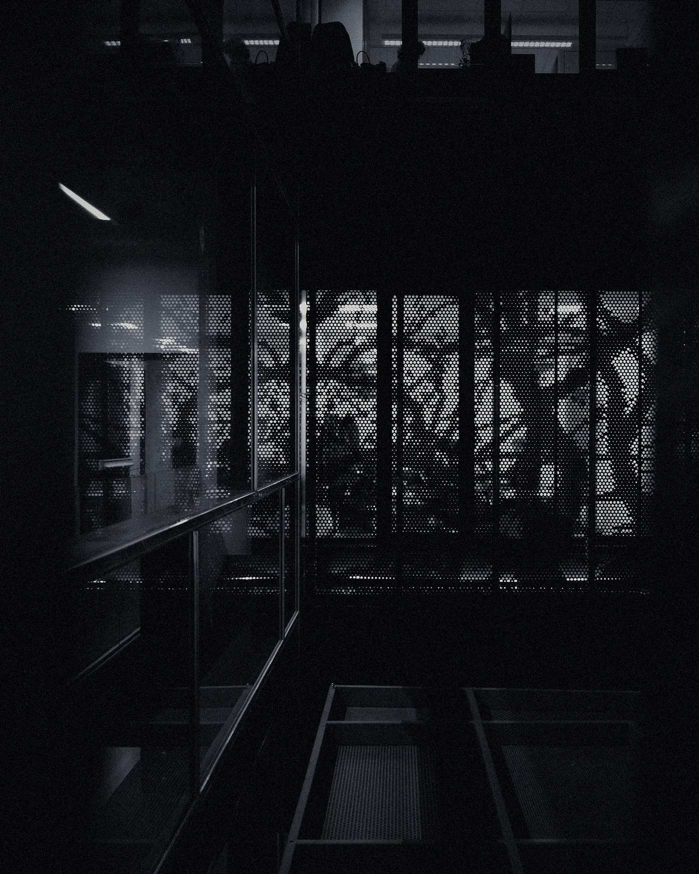 A dark office behind a glass wall