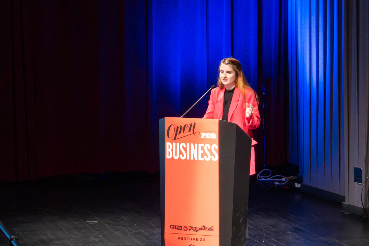 woman standing at a podium delivering a presentation