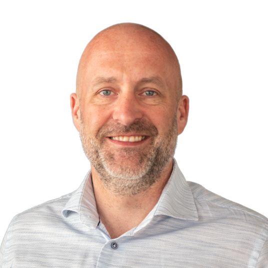 Natural rock arch framing desert landscape at sunset