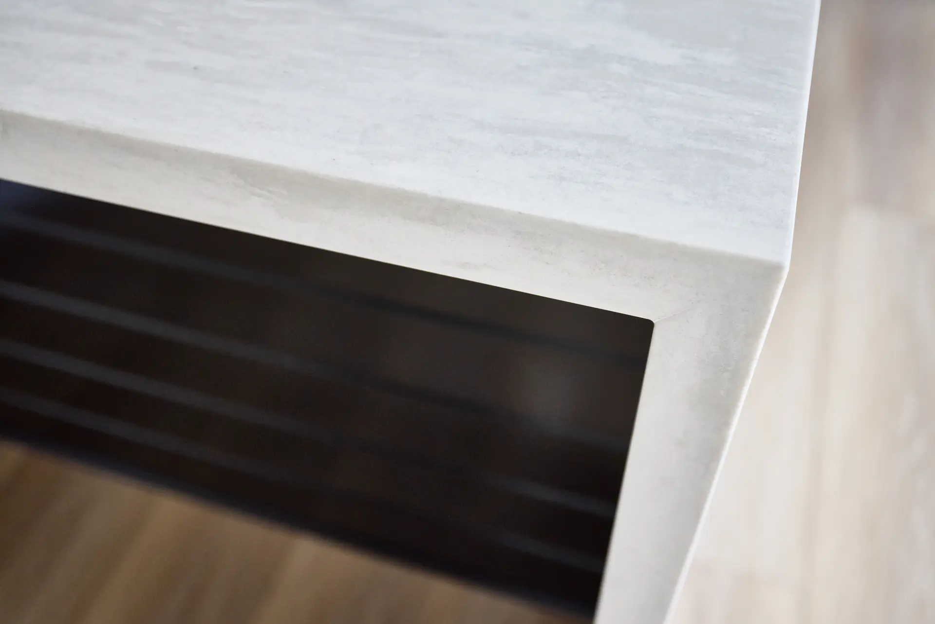 Close-up of the kitchen countertop and bartop in ADU Orange, showcasing the sleek black finish and contemporary design. Photo by Todd Huge.
