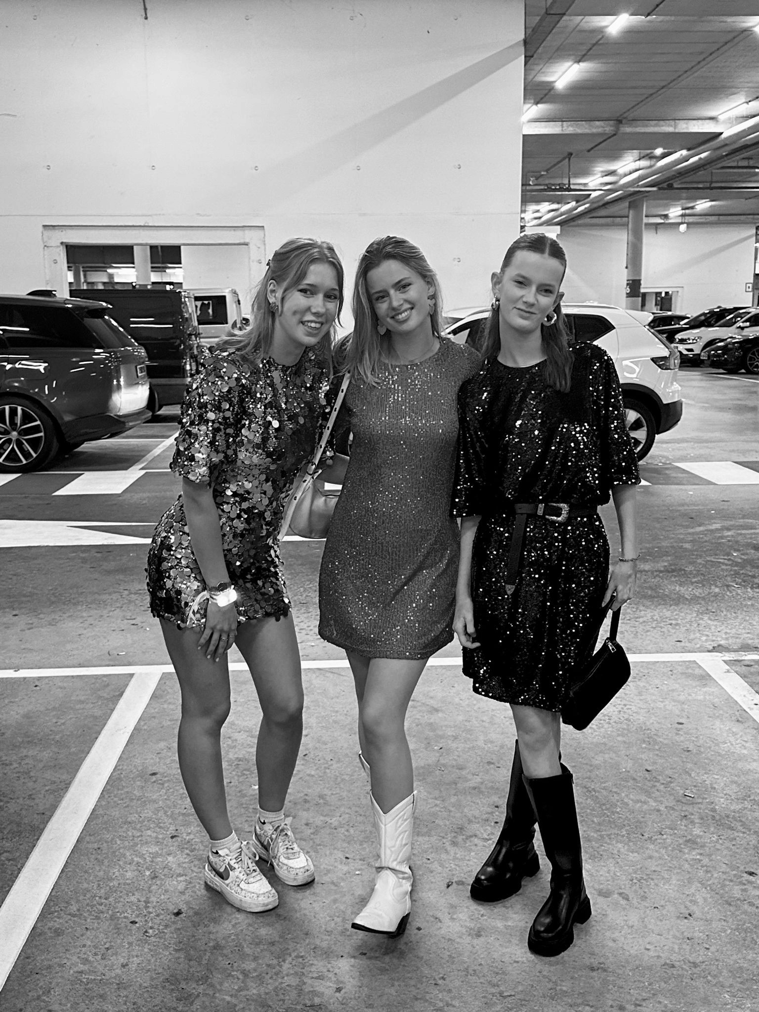 black and white photo of three girls in glitter dresses posing together for a photo