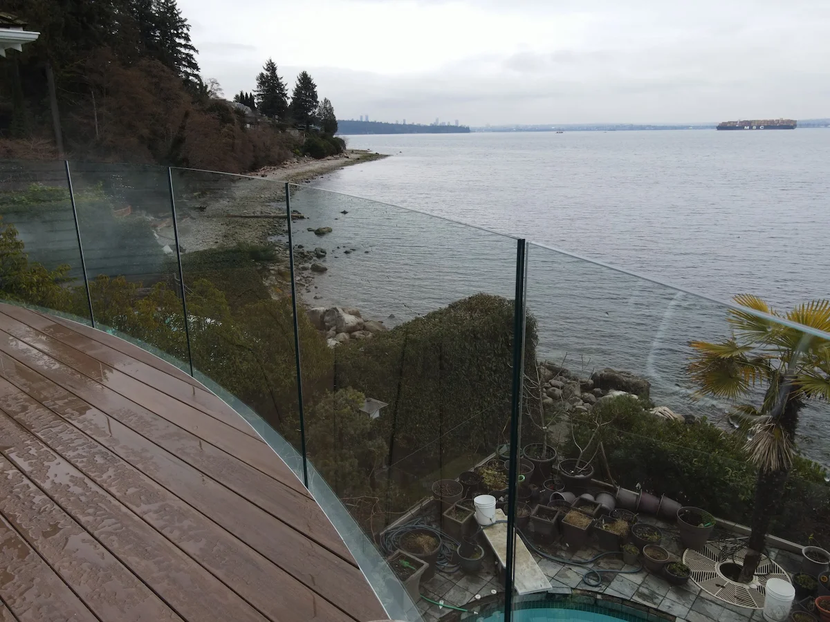 Curved glass railing system at a public property, designed to meet safety requirements while preserving open coastal views.