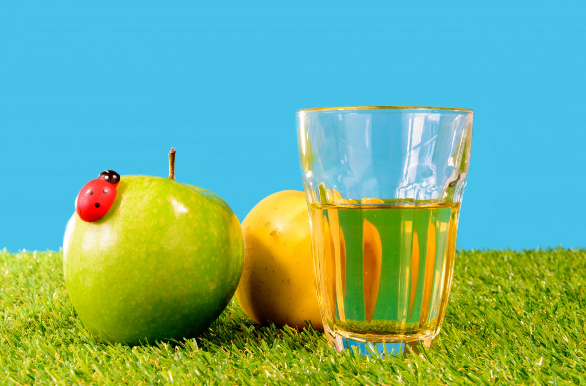 Glass of water and fresh fruits on a table, representing hydration and weight tracking simplified by Caloric