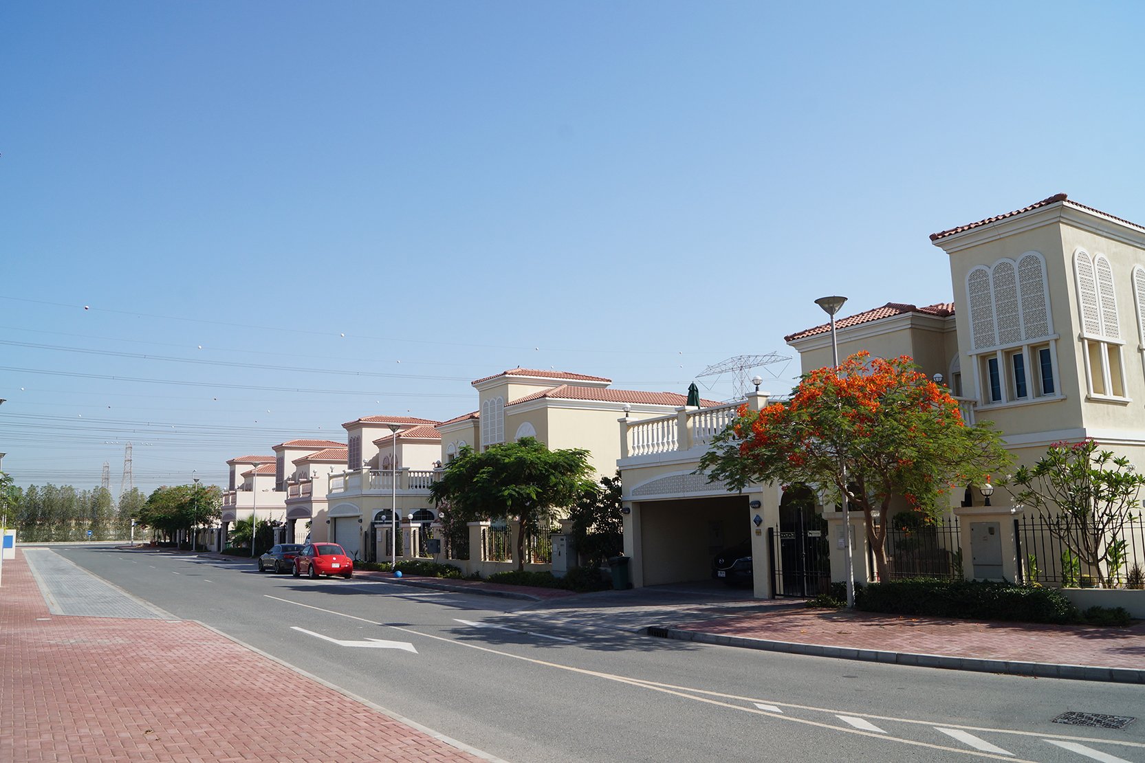 A red car drives down a street with a red and white building labeled 'District 1' in the background.