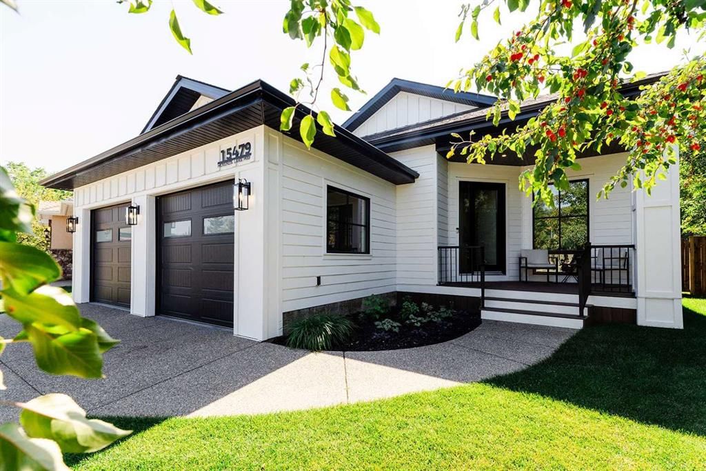 Fresh white board-and-batten Hardie siding with black fascia and garage doors in Calgary