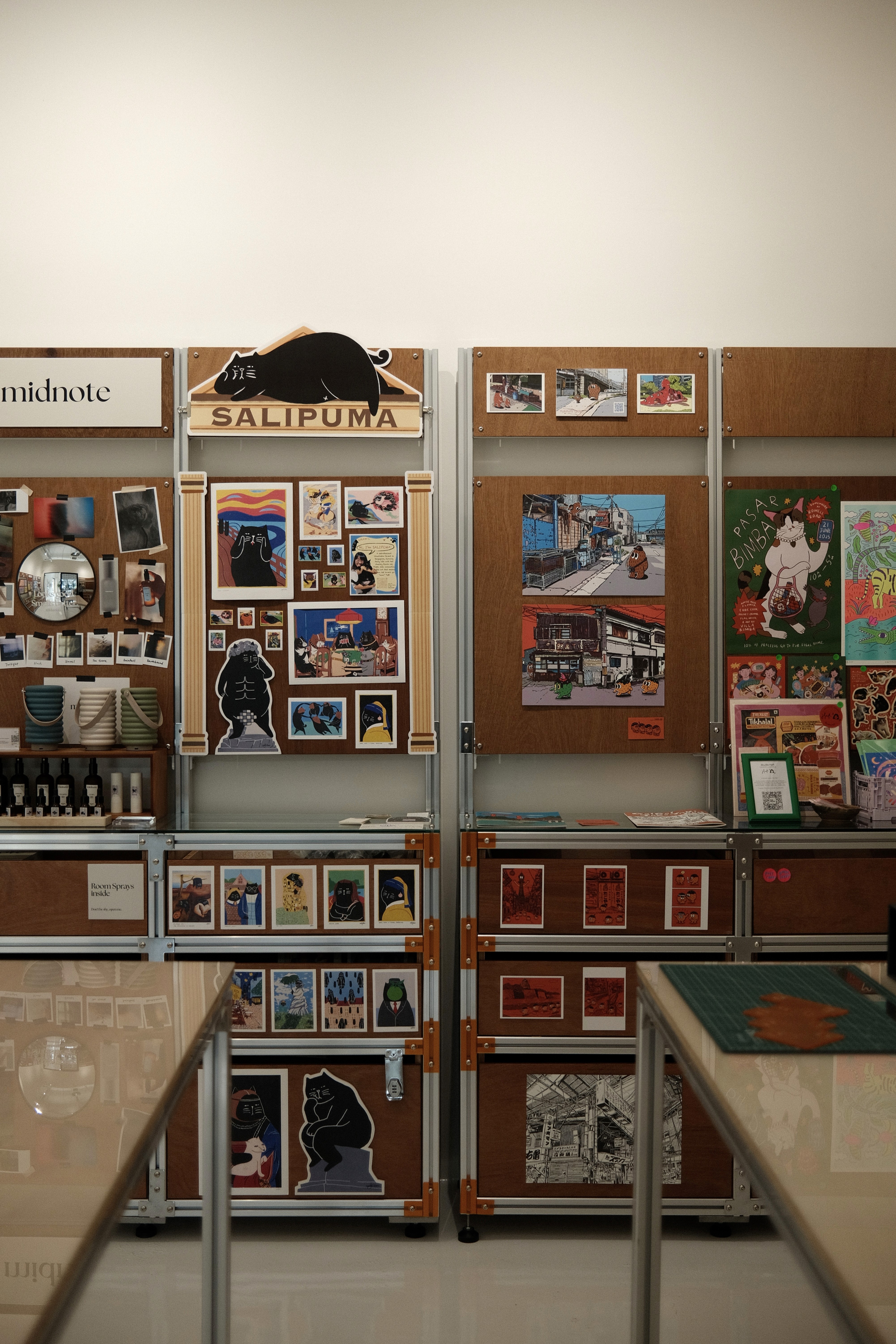 A dedicated creative market space designed for local artists to showcase their work, where modular displays and warm timber finishes frame a rotating collection of illustrations and objects. Open and welcoming, the Irusu showroom offers free entry, inviting visitors to explore and engage with the local creative community.