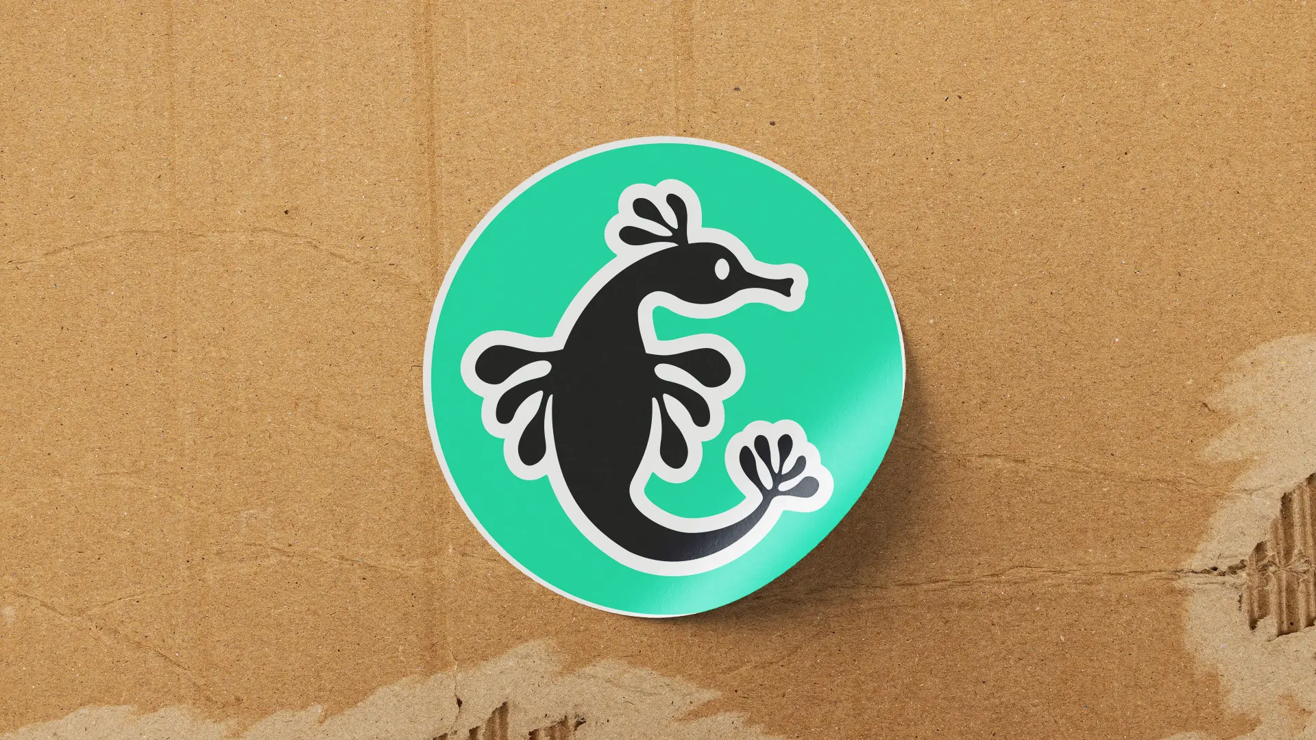 A round green sticker featuring a black silhouette of a creature with a long tail and playful design.