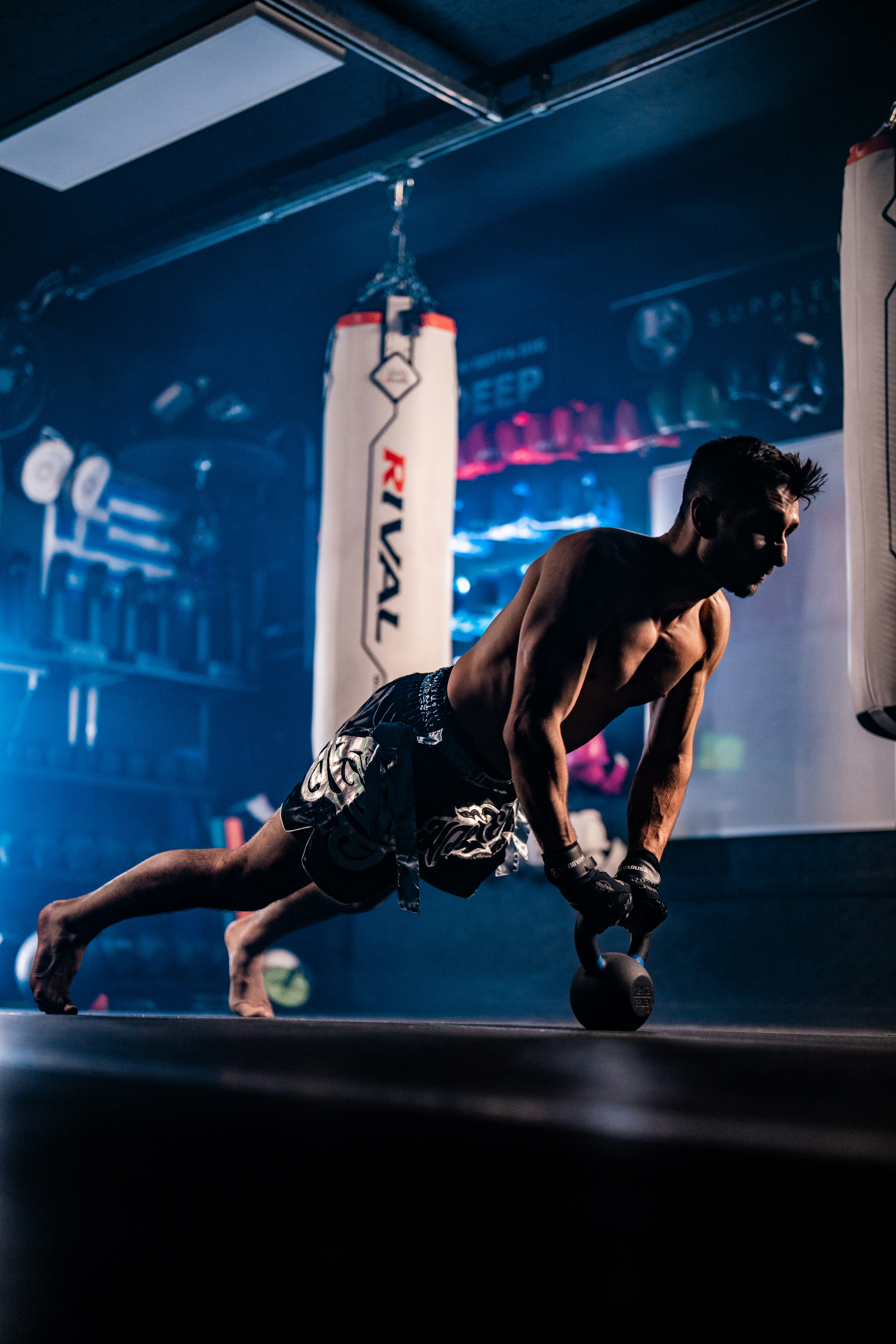 Man doing a kettlebell push-up in a gym