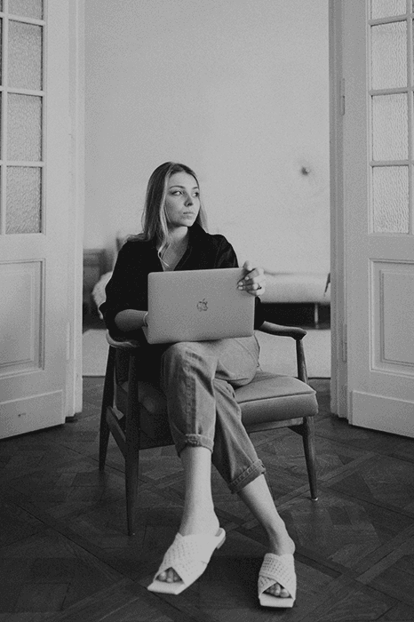 Young woman working on a laptop in a chair, Suprematic branding and web studio, Warsaw