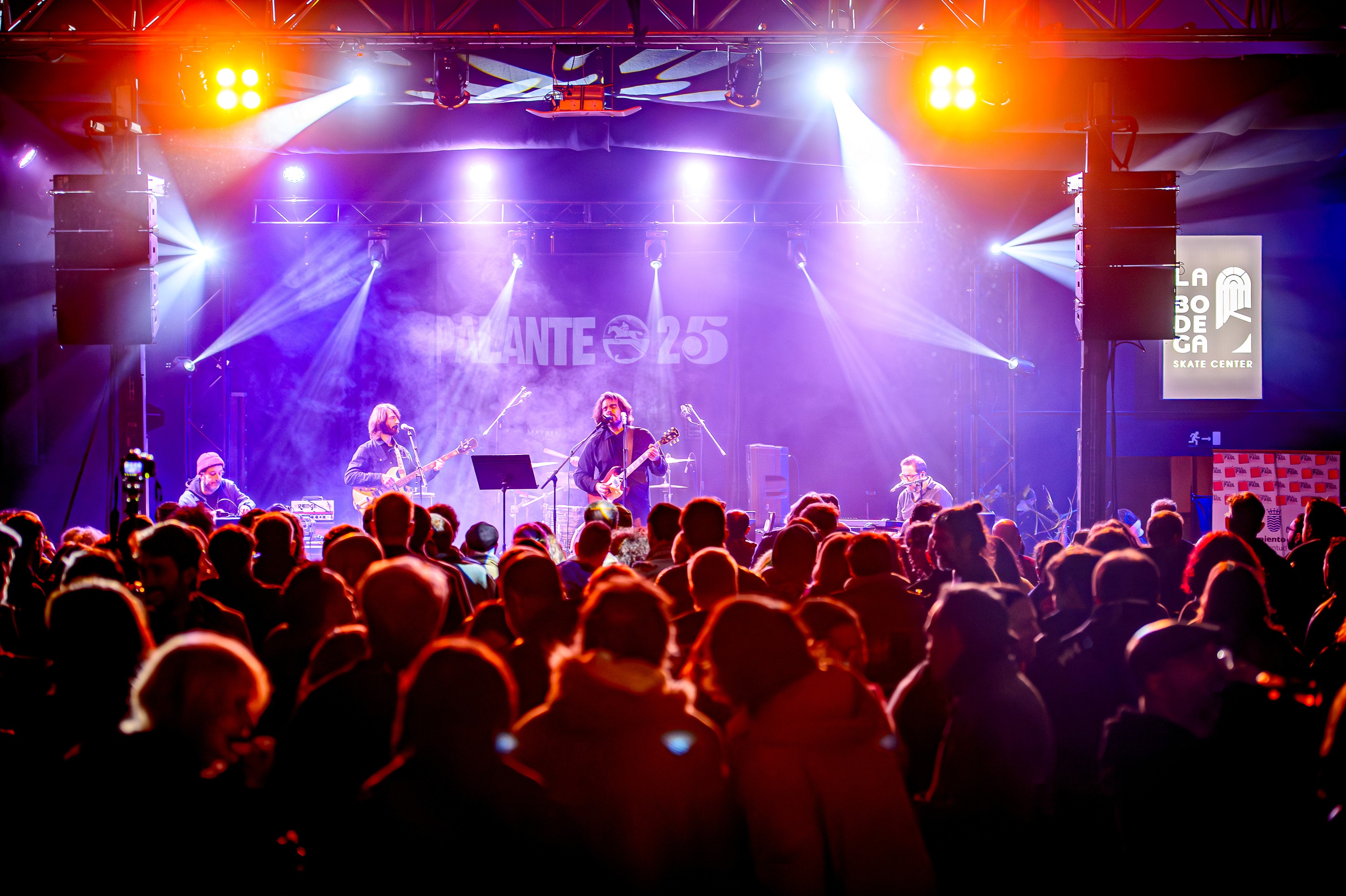 Young leady in green sweater asks a question into a conference mic.