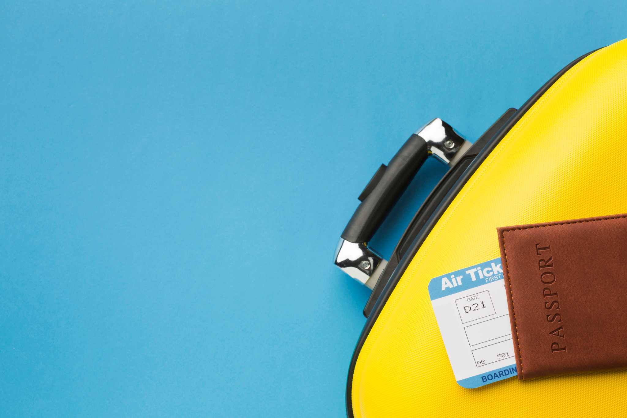 Landscape with a vineyard in rows leading to a building with a tower, rolling hills in the distance.