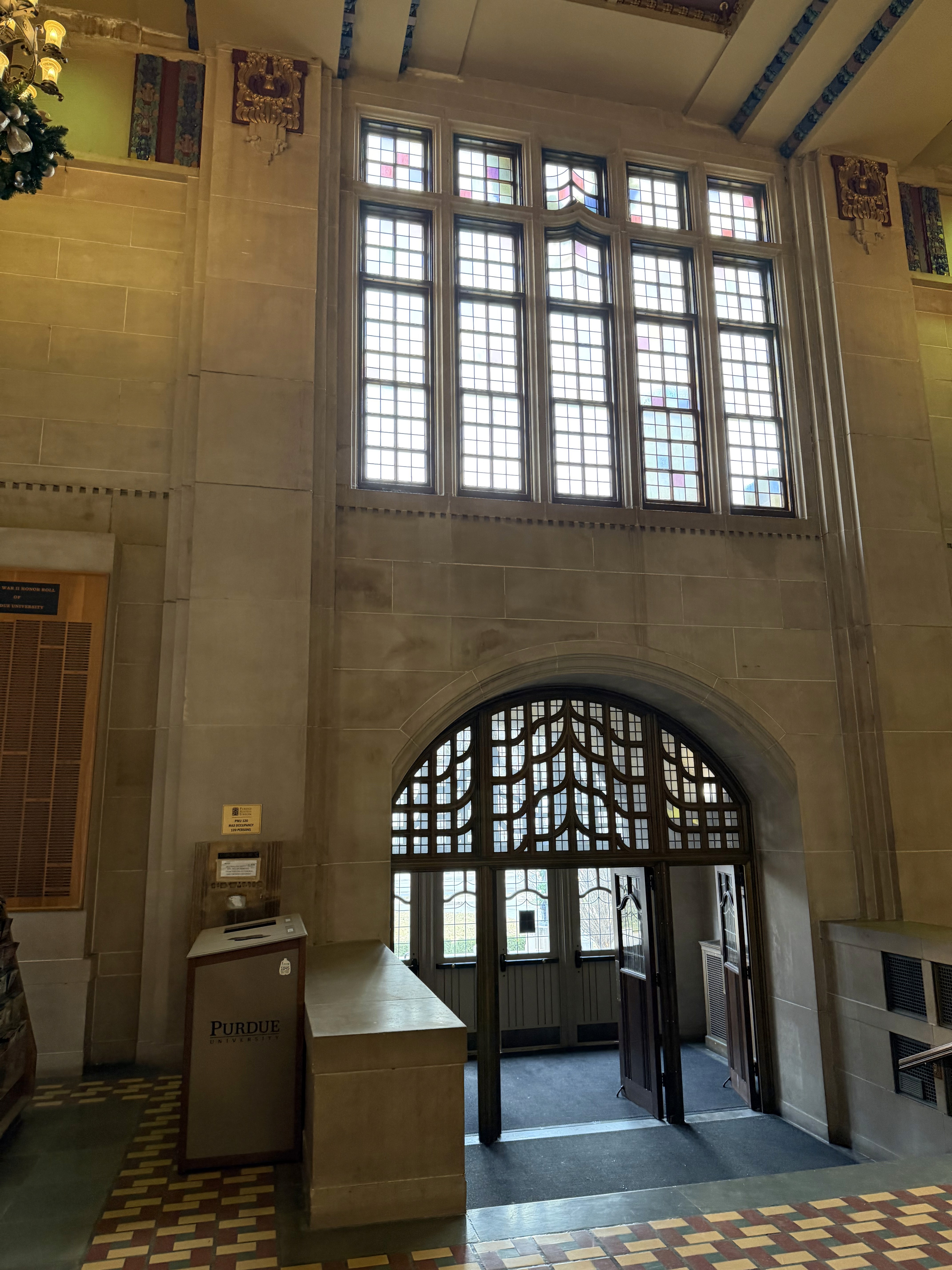 A cozy room with a wooden desk, computer, and warm sunlight streaming through a window.