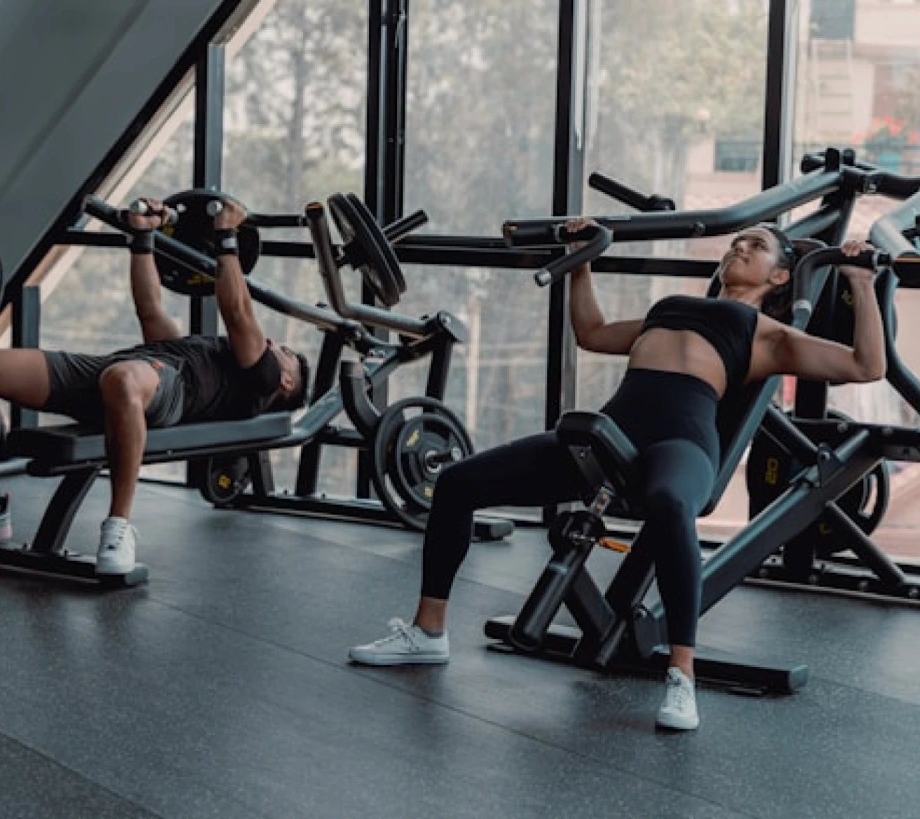 Two people using rowing machines in a fitness club