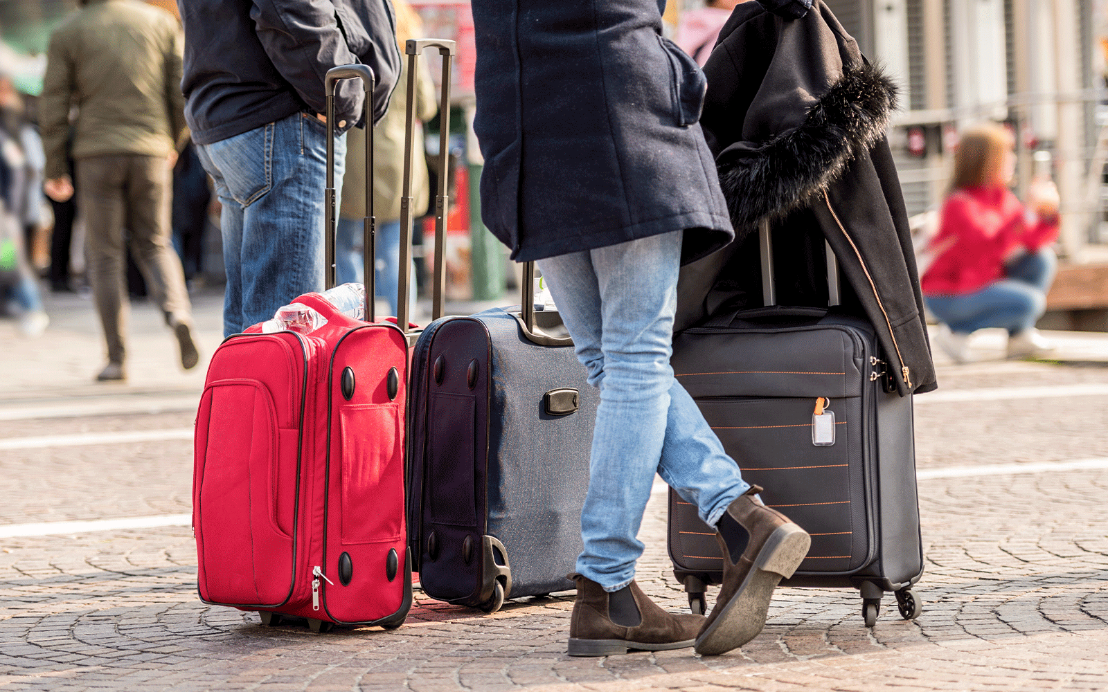 นักท่องเที่ยวพร้อมกระเป๋าเดินทางบนถนนในเมือง