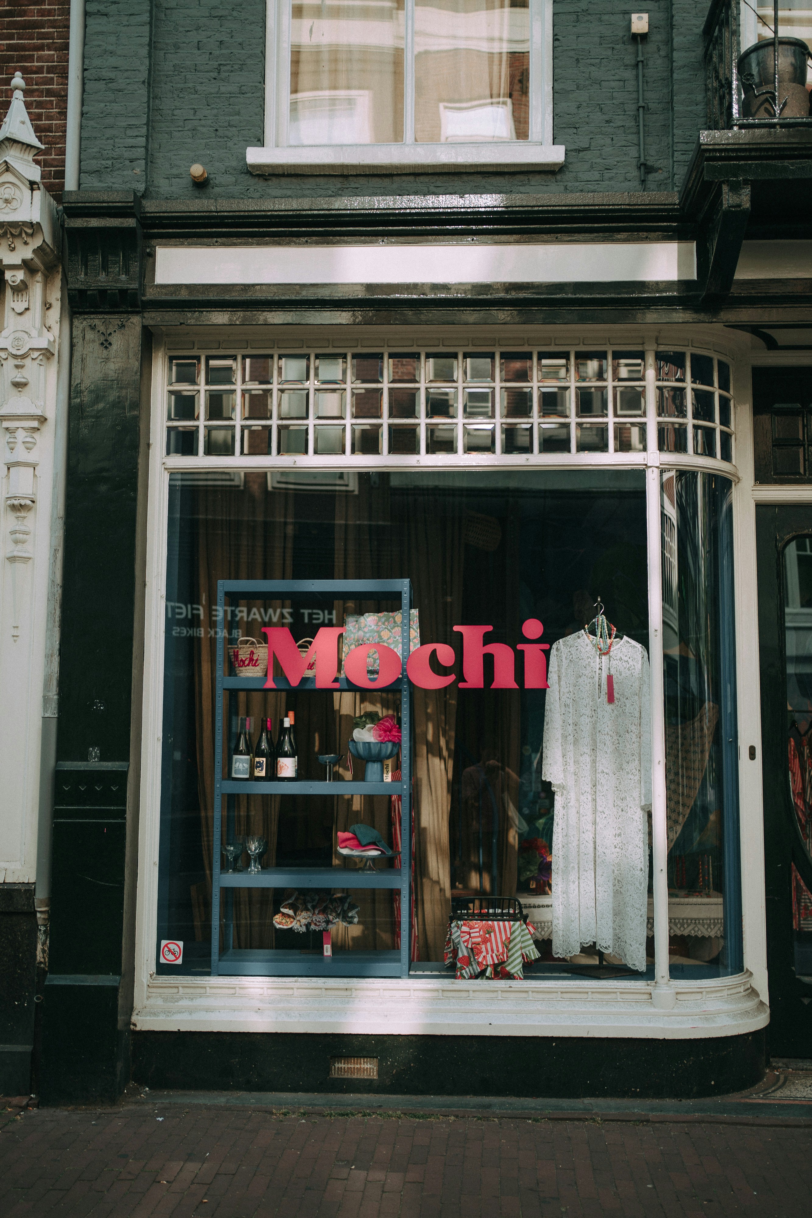 Storefront window display with "mochi" sign and clothing