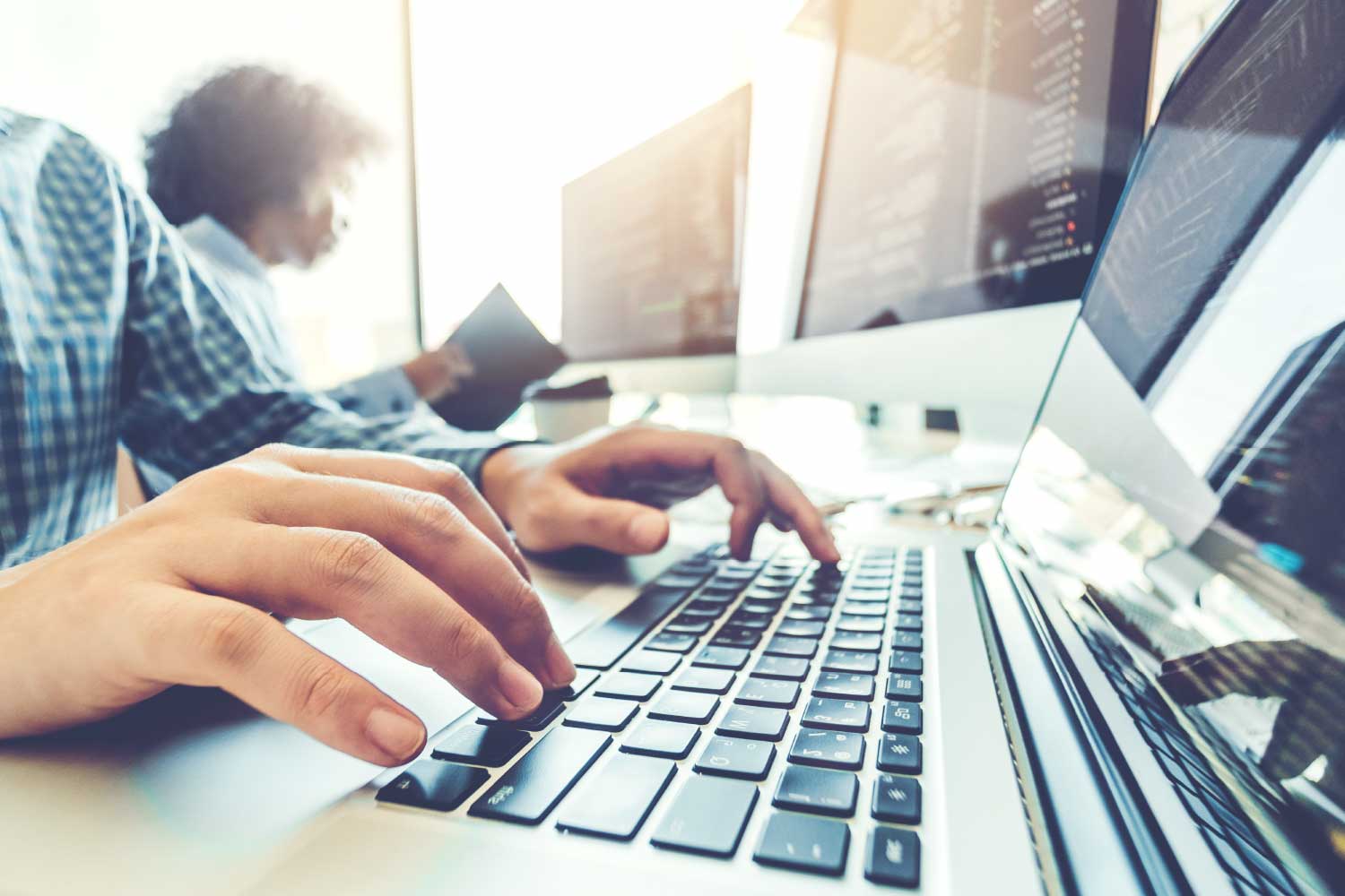 Profissional digitando código em notebook, representando desenvolvimento de software e programação em TI - FindUP - Nota fiscal eletrônica MEI