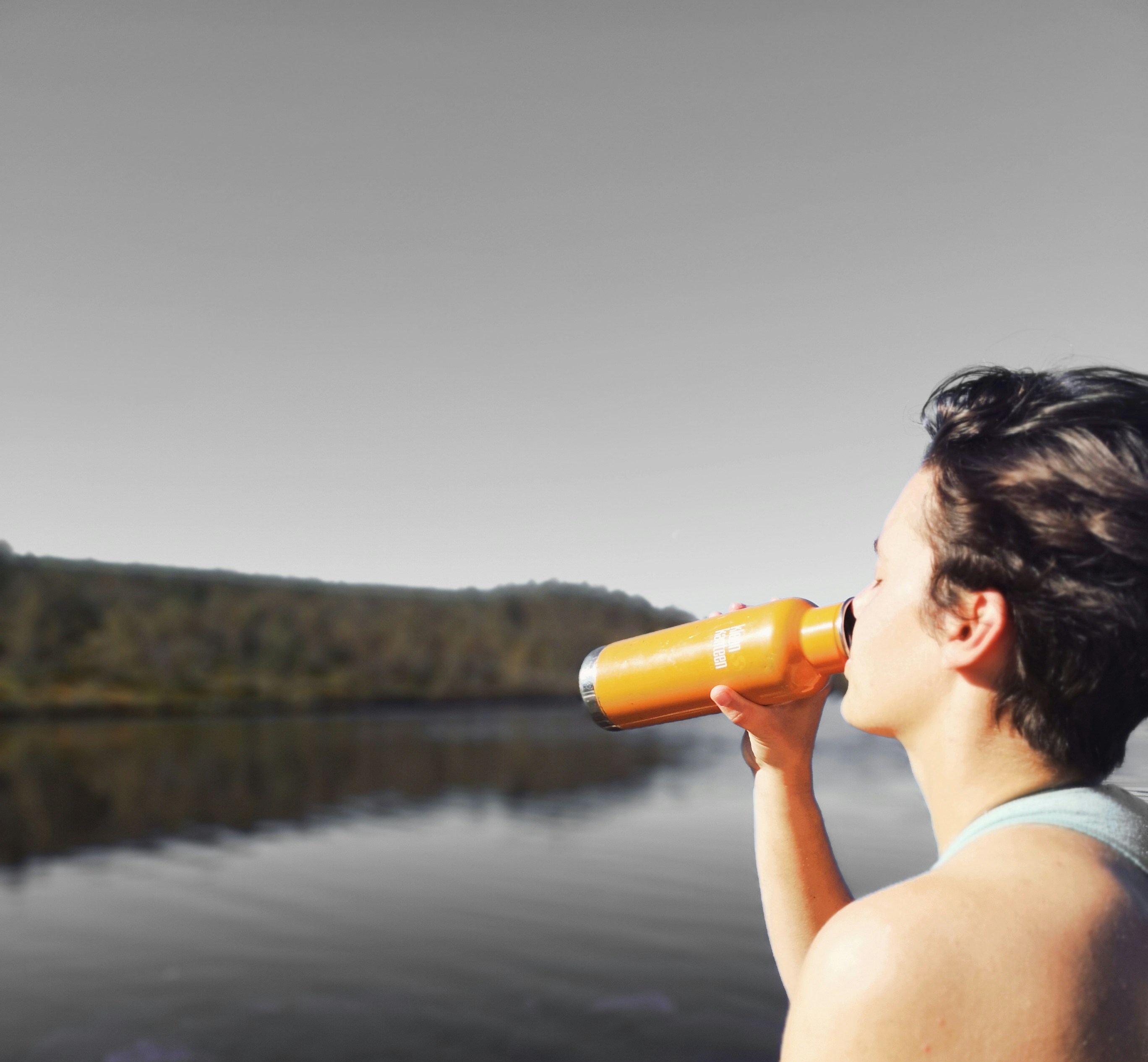 a woman drinking water from her water bottle