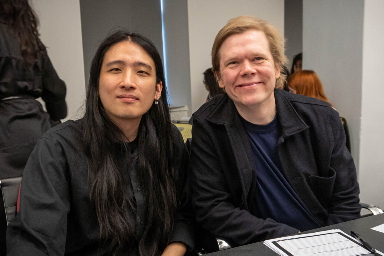 two people smiling, looking at the camera