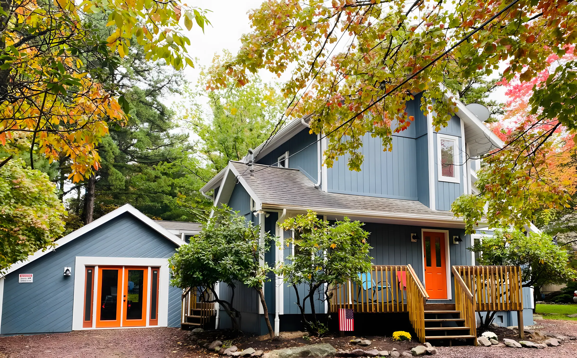 Blue-gray two-story home with orange doors and fall trees at Beechwood Bliss, Lake Harmony, PA