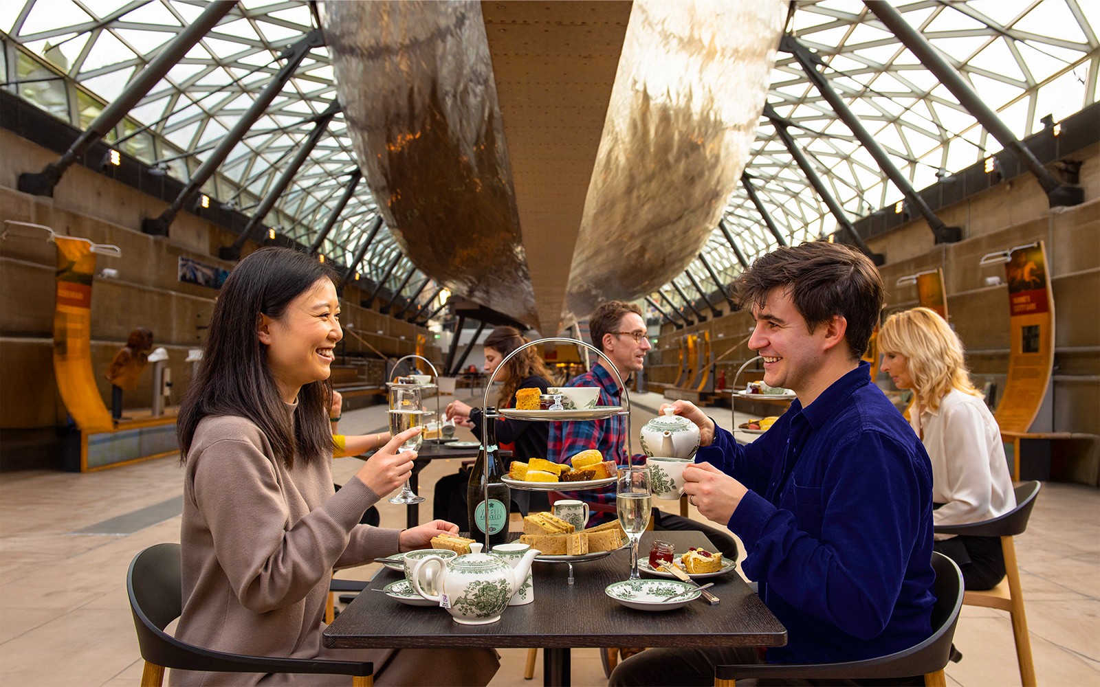 Guests enjoying afternoon tea under the Cutty Sark in London.