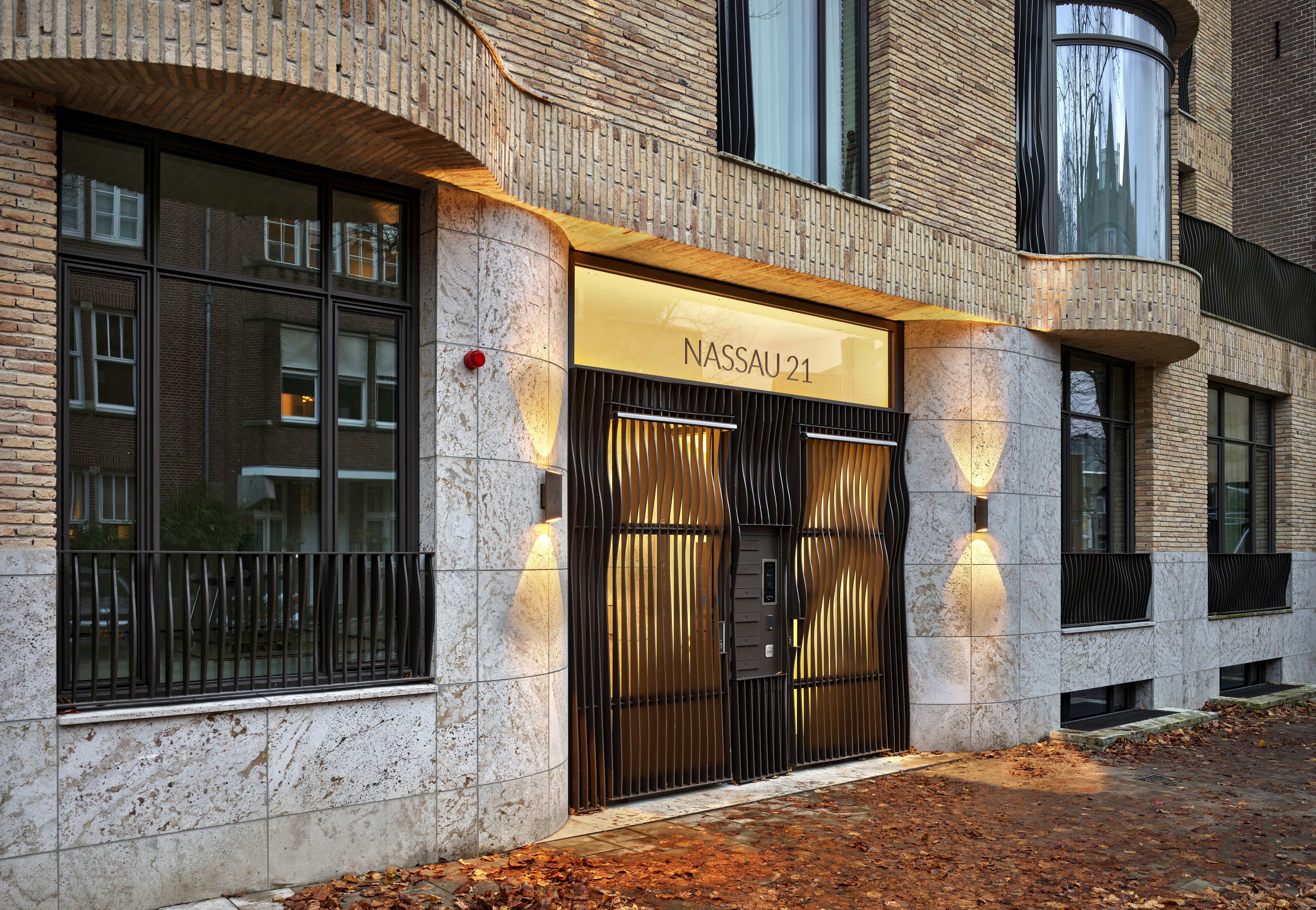 Gevel van een gebouw met stenen en grote metalen deuren met opschrift Nassau 21.