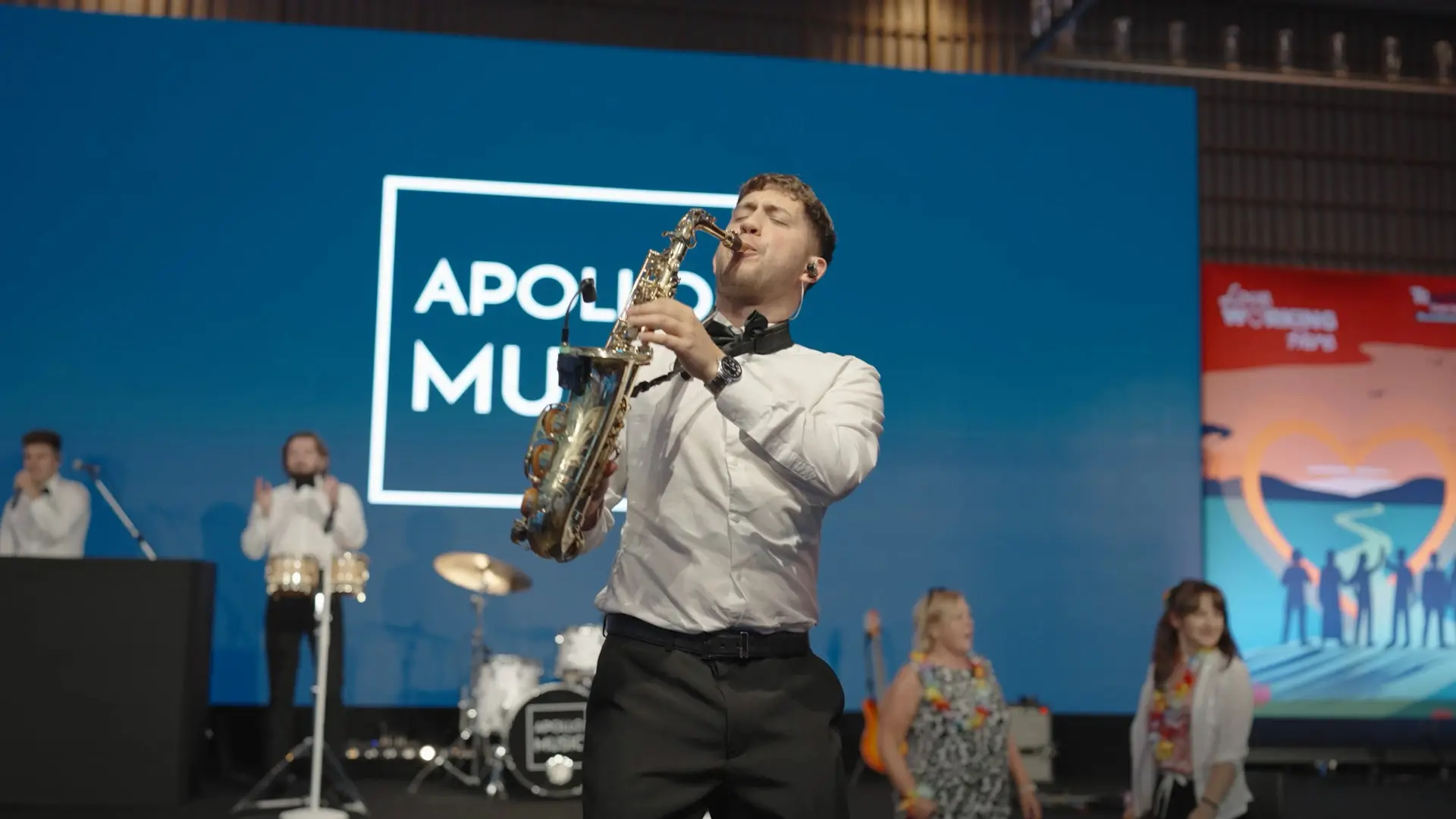 Live saxophonist performing on stage during the Bupa Care conference evening entertainment.
