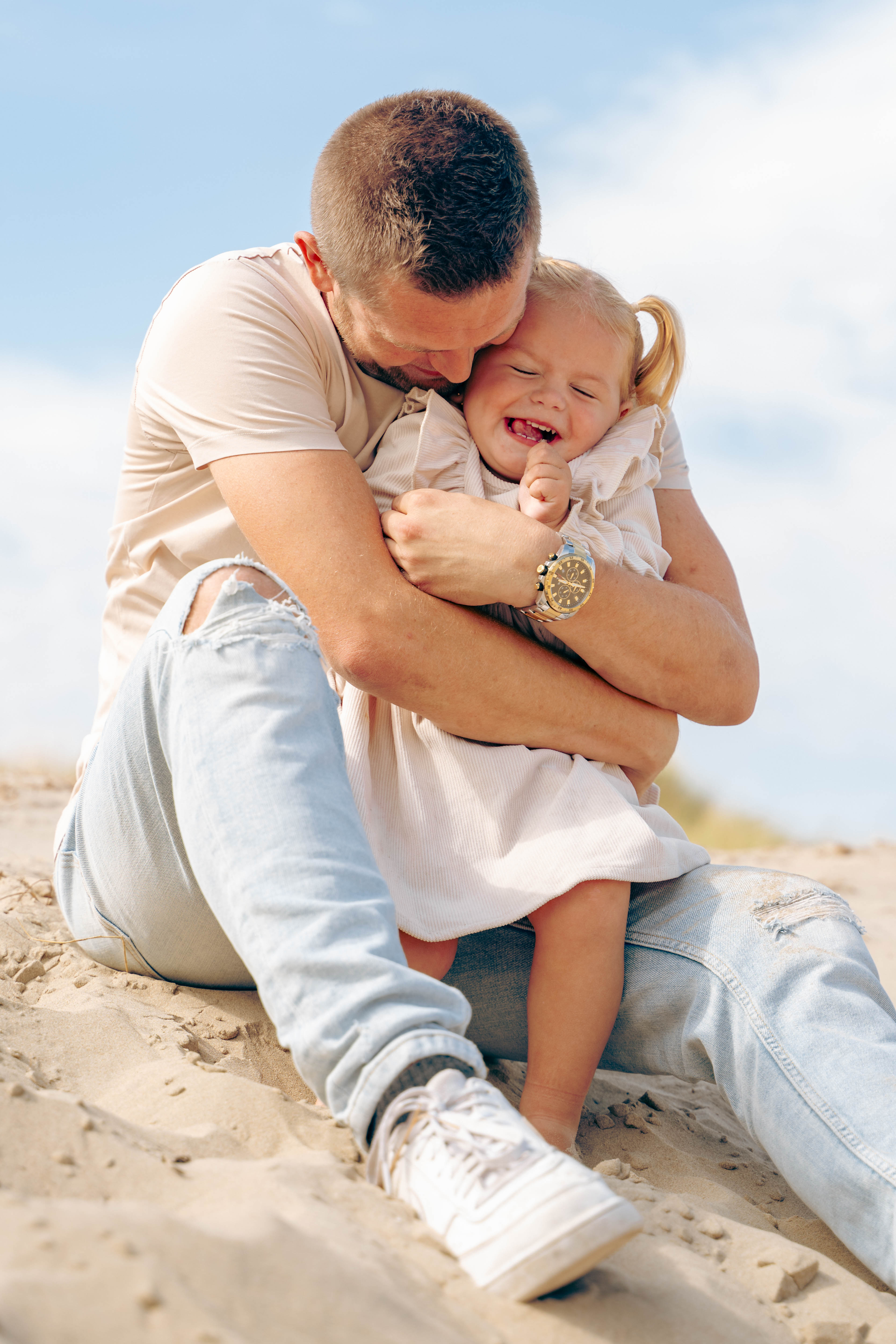 A bride and groom share a kiss surrounded by a joyful bridal party.